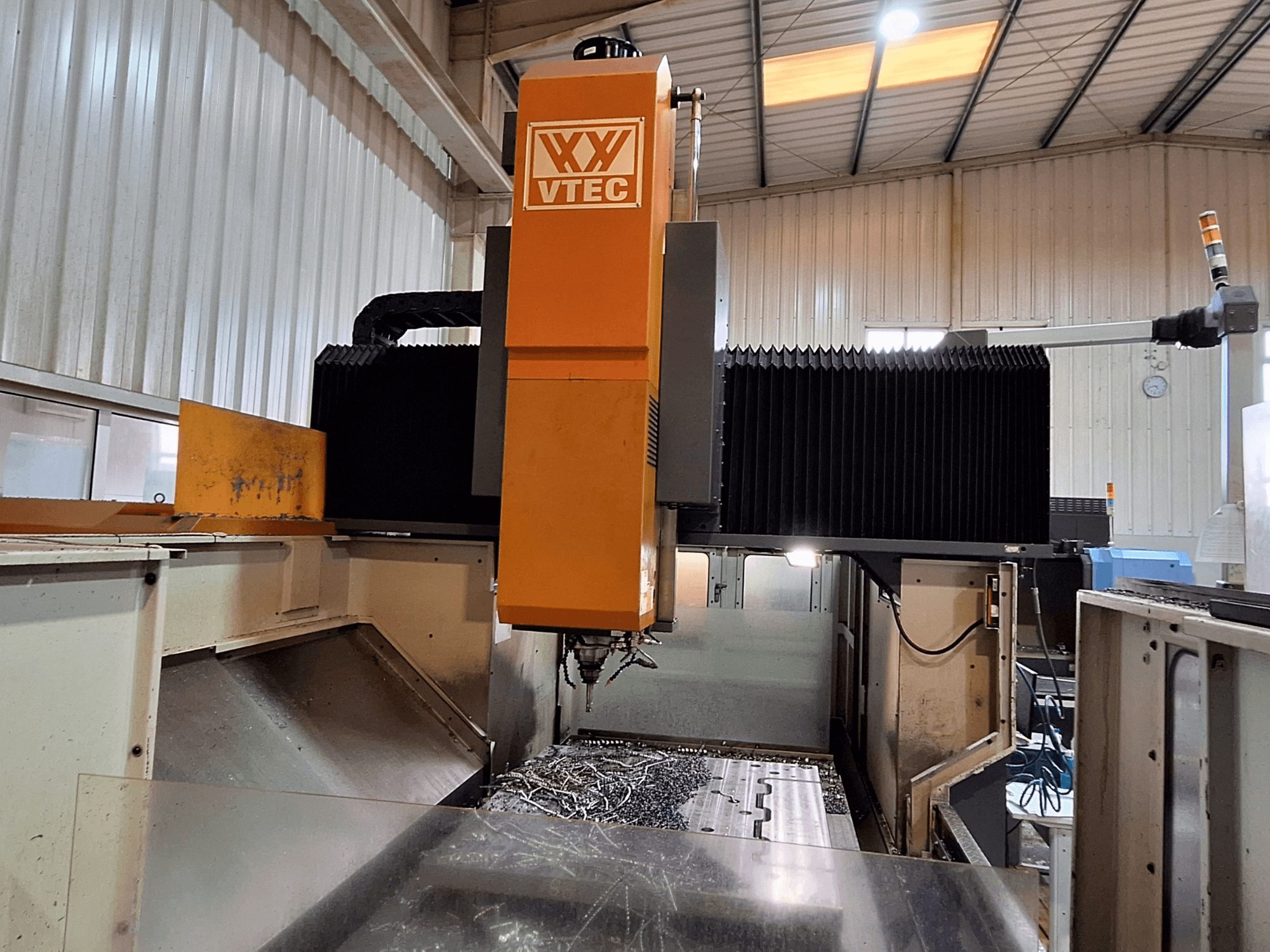 Portaalfreesmachine van PORTIC, model VTEC, vooraanzicht met zichtbaar snijgereedschap en metaalschilfers.