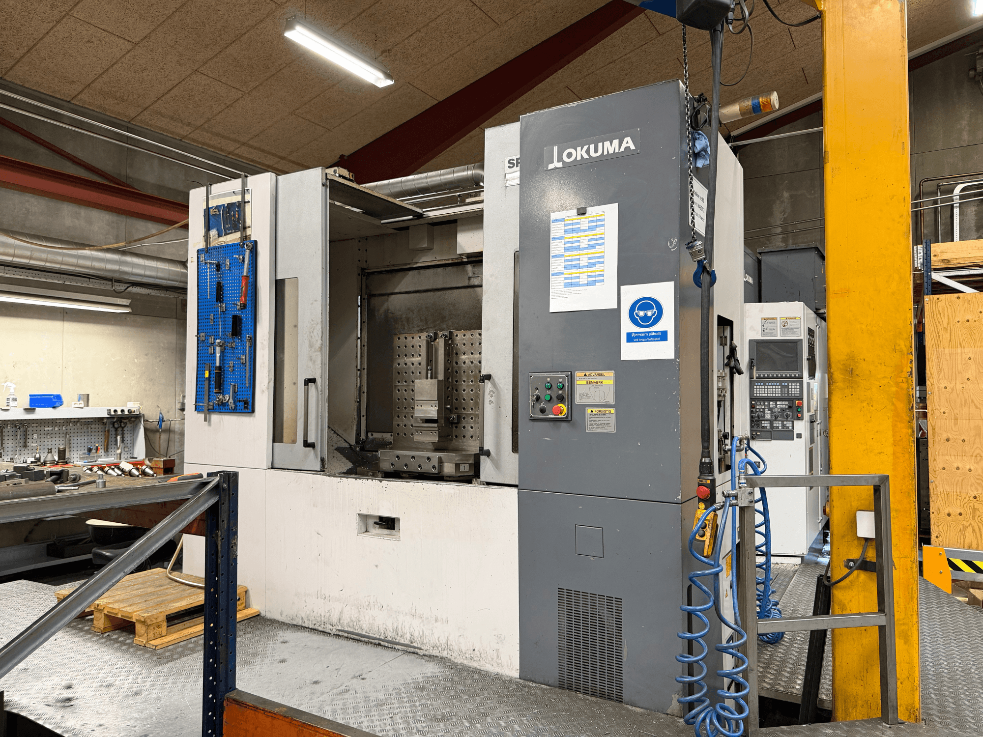 Okuma MA-600HB horizontaal bewerkingscentrum in een werkplaats, vooraanzicht met bedieningspaneel en werkgebied.
