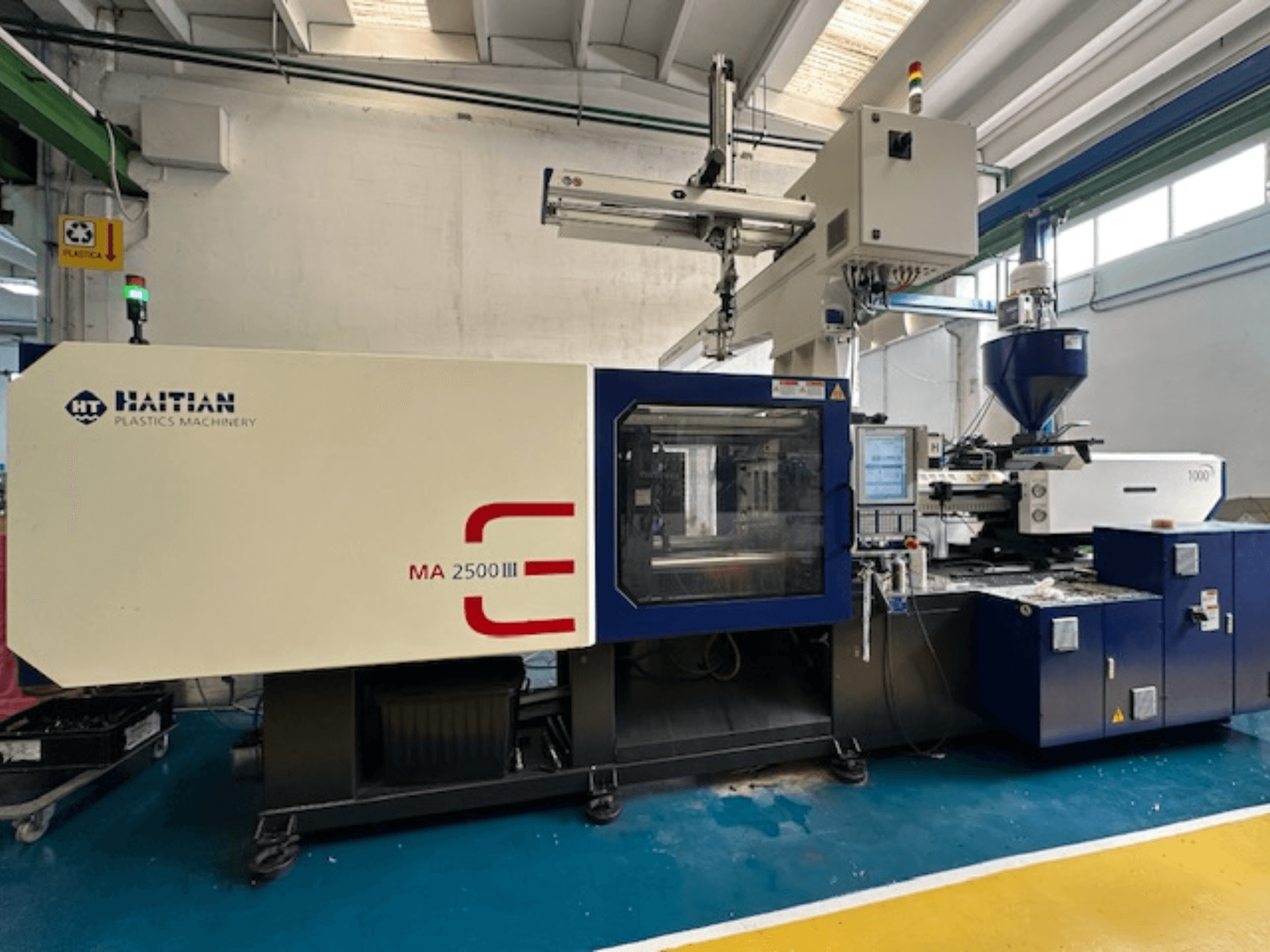 Hydraulische spuitgietmachine MA 2500 III uit Haïti, vooraanzicht van bedieningspaneel en trechter.