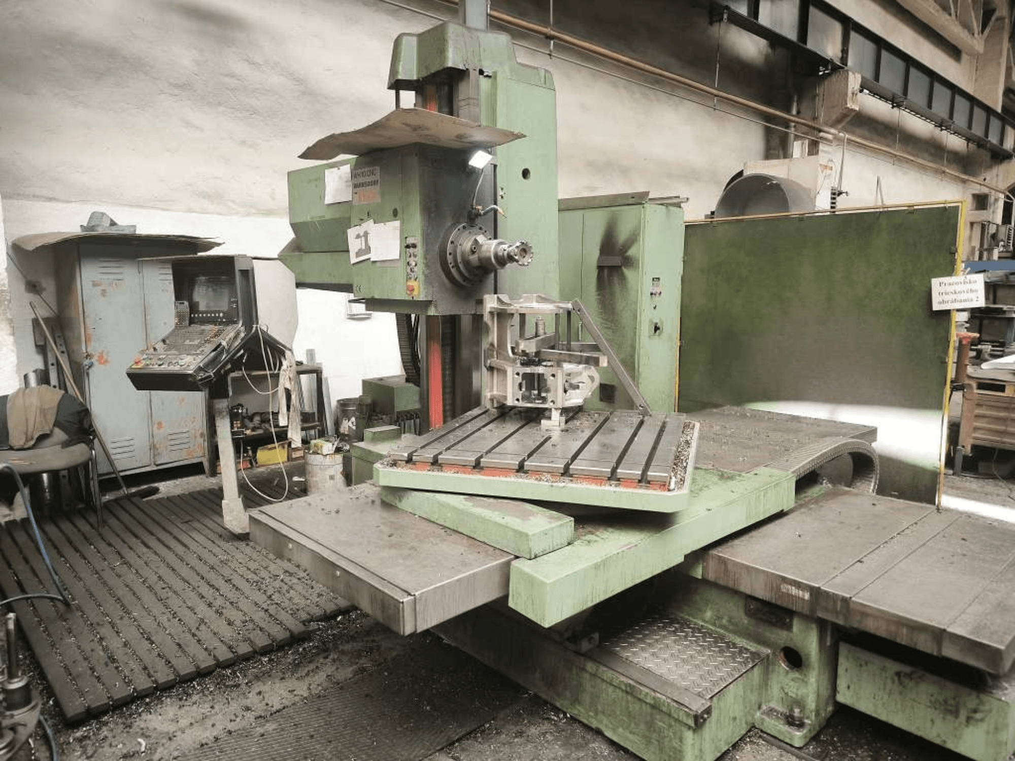 De TOS WH 10 CNC-boormachine, gezien vanaf de voorkant, met een bewerkt werkstuk op de tafel en het bedieningspaneel.