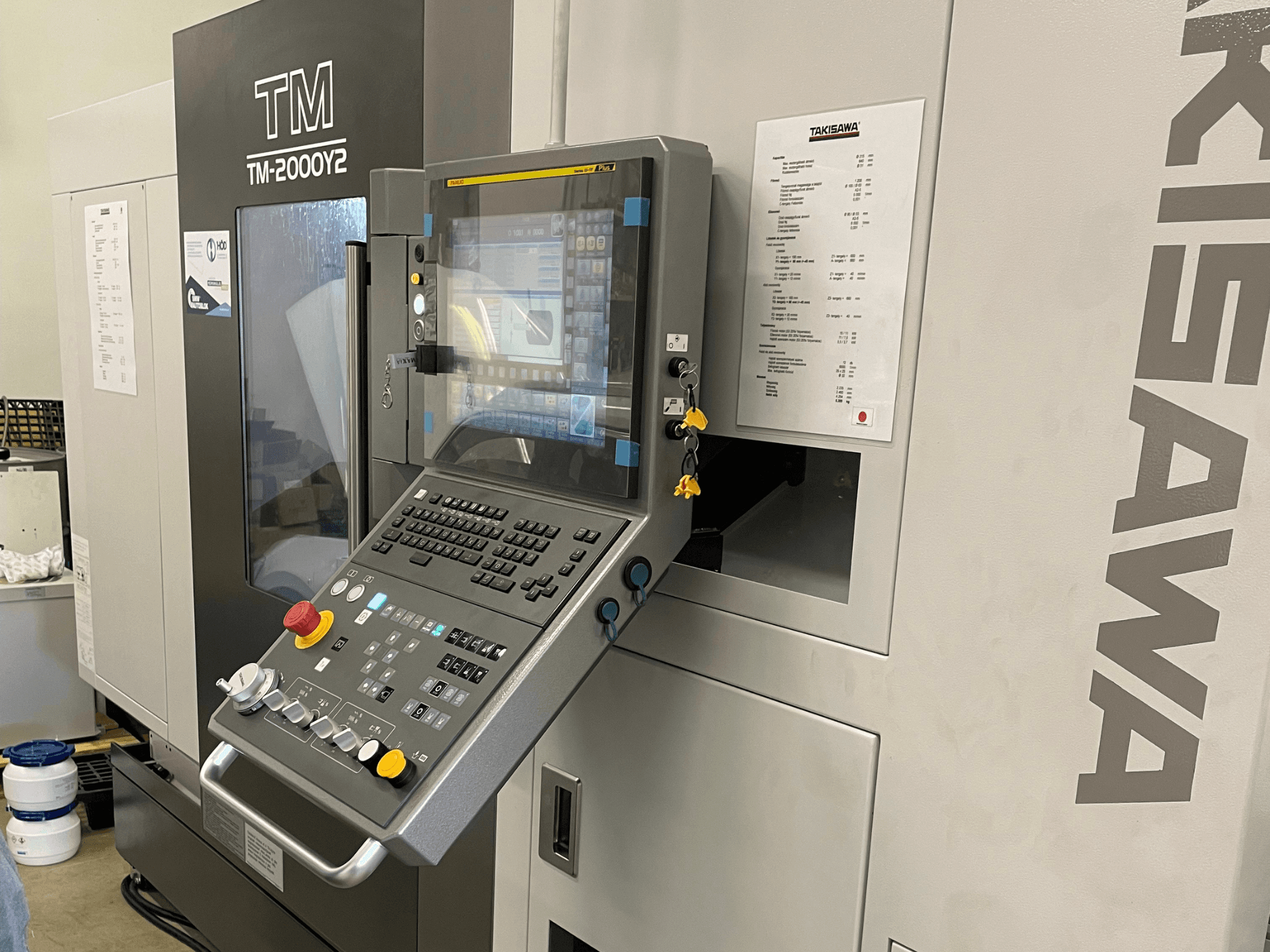 Het bedieningspaneel van de Takisawa TM-2000Y2 horizontale draaimachine in vooraanzicht, met een digitaal display en bedieningsknoppen.