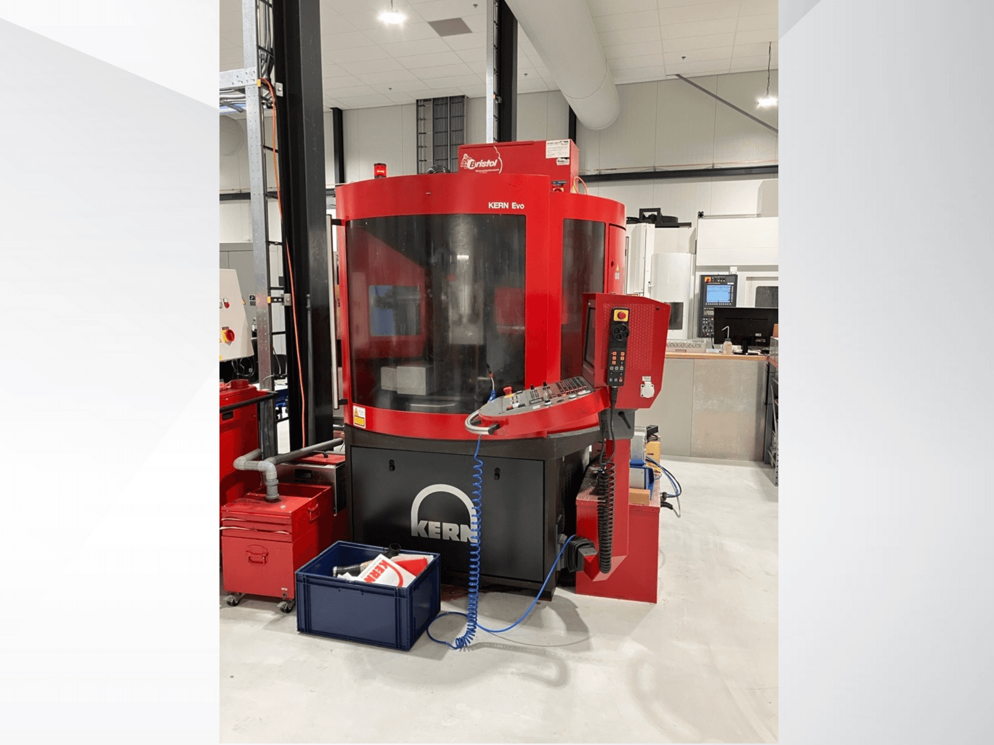 KERN Evo bewerkingscentrum in rood en zwart, vooraanzicht, met bedieningspaneel en omringende apparatuur in een moderne werkplaats.