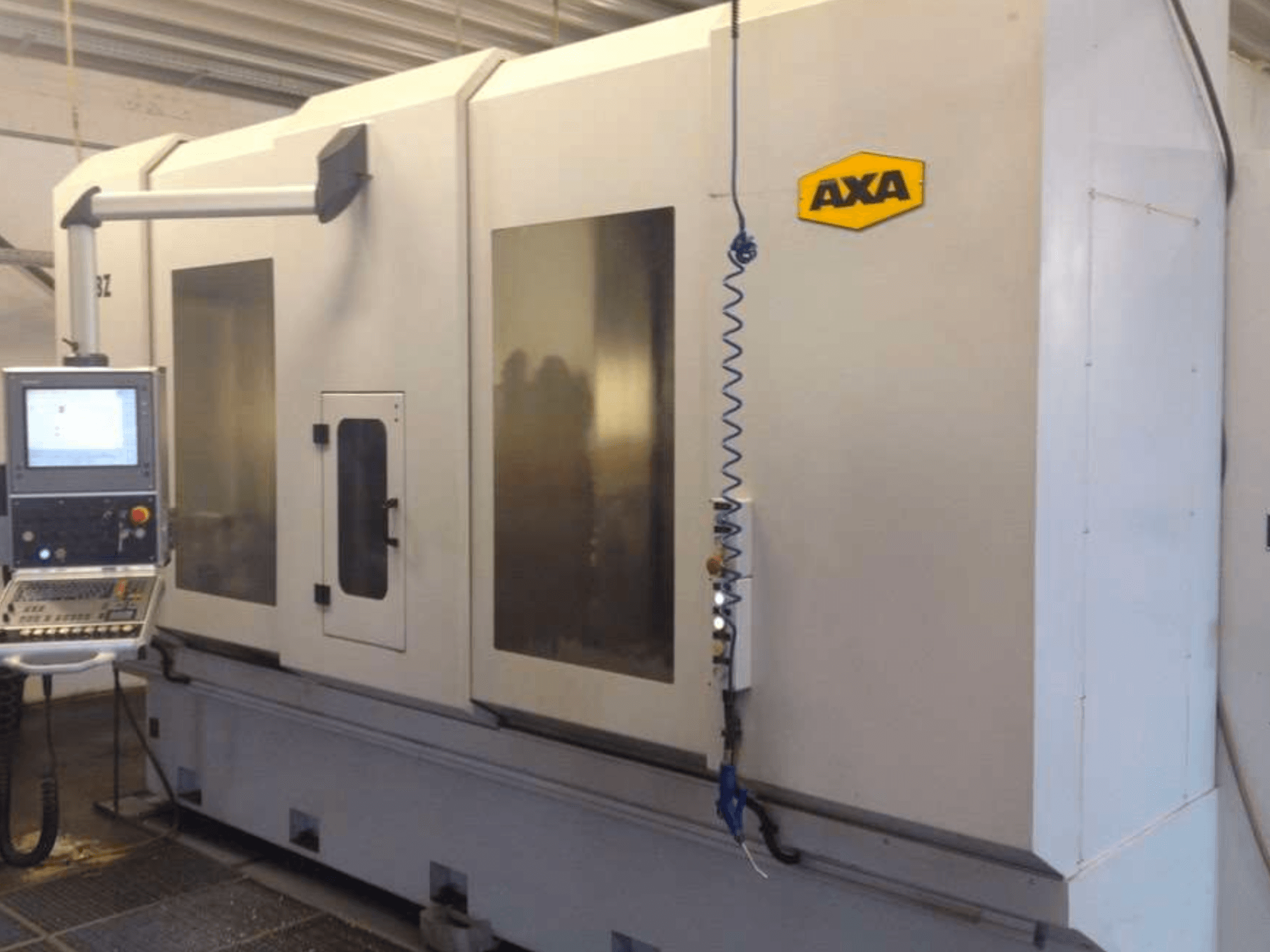 AXA DBZ verticaal bewerkingscentrum gezien vanaf de voorkant, met een bedieningspaneel en grote transparante veiligheidsramen.