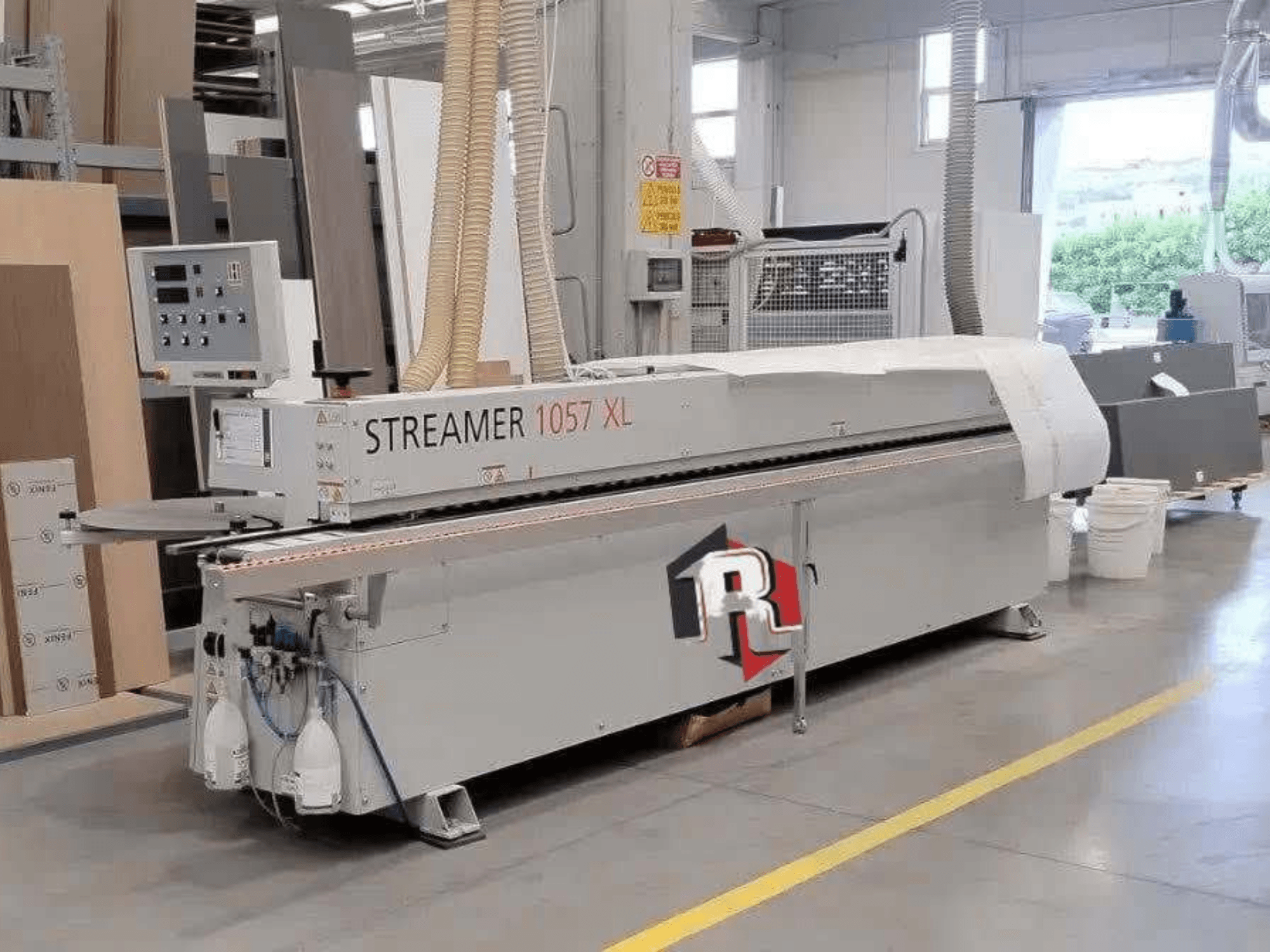 HOLZHER STREAMER 1057 XL kantenlijmmachine in een werkplaats, zijaanzicht met zichtbaar bedieningspaneel en luchtslangen.
