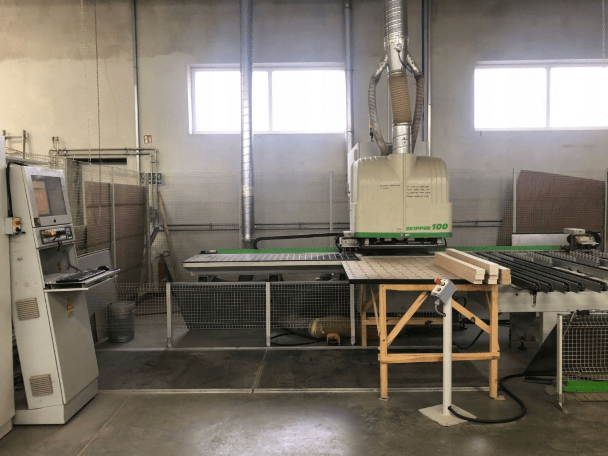 BIESSE SKIPPER 100 CNC-bewerkingscentrum in een werkplaats; op de foto aan de voorkant is de machine te zien met het bedieningspaneel en hout op de werktafel.