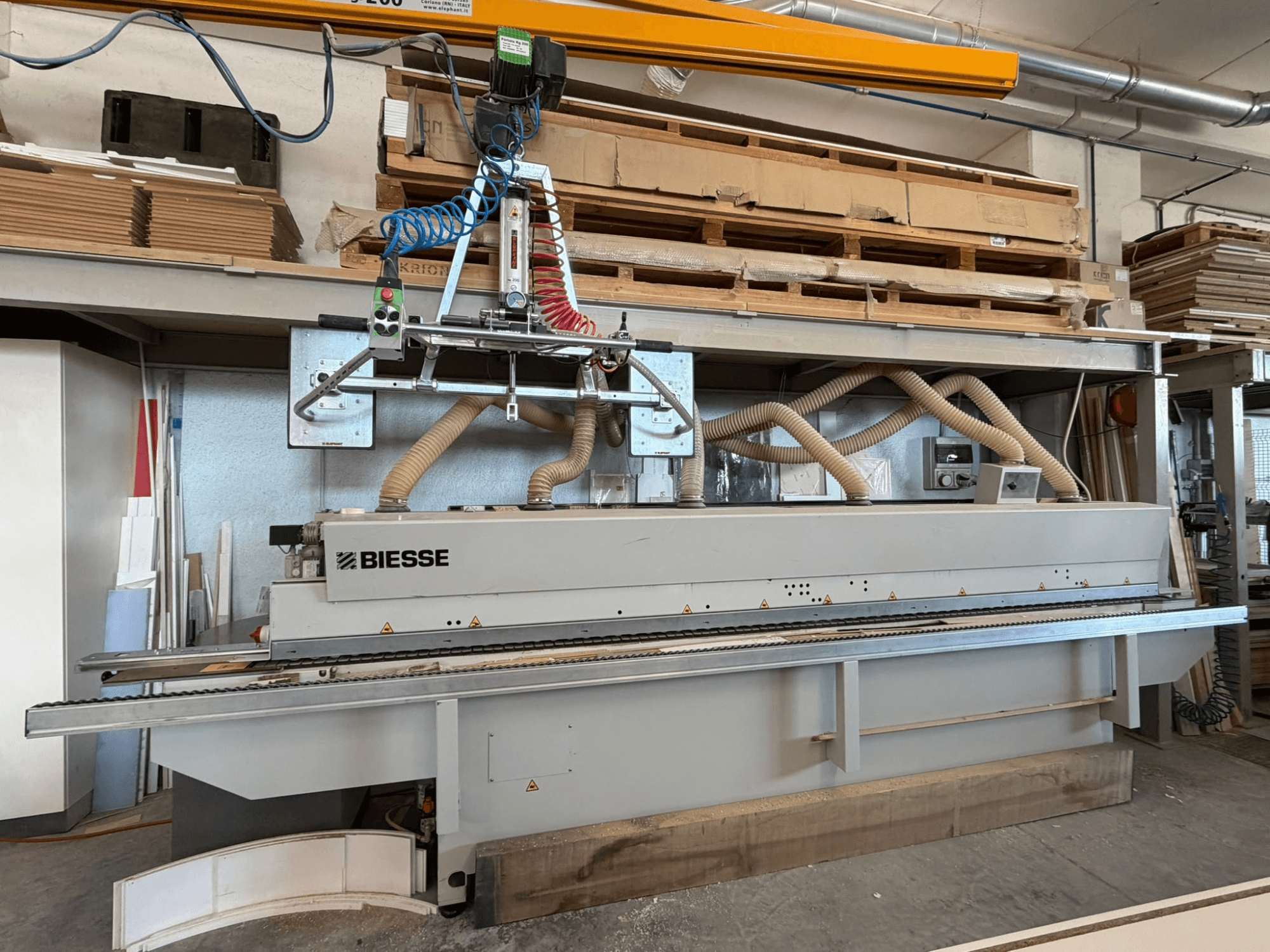 BIESSE AKRON 1330 kantenlijmmachine in een werkplaats, gezien vanaf de voorkant met bedieningspaneel en stofafzuigsysteem.
