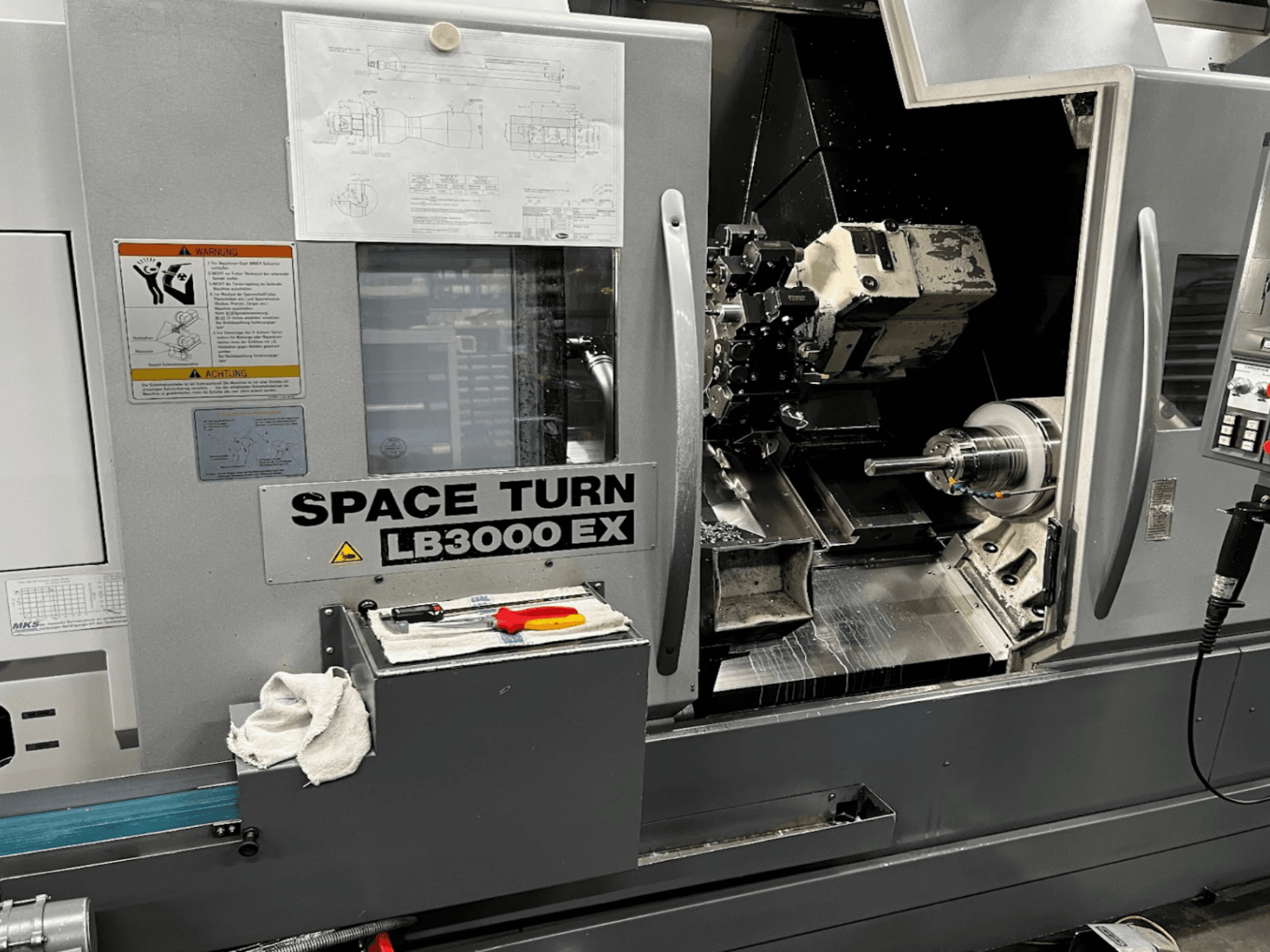 Okuma LB3000EX MYW horizontale draaimachine, vooraanzicht met bedieningspaneel, gereedschappen en details van de werkruimte zichtbaar.