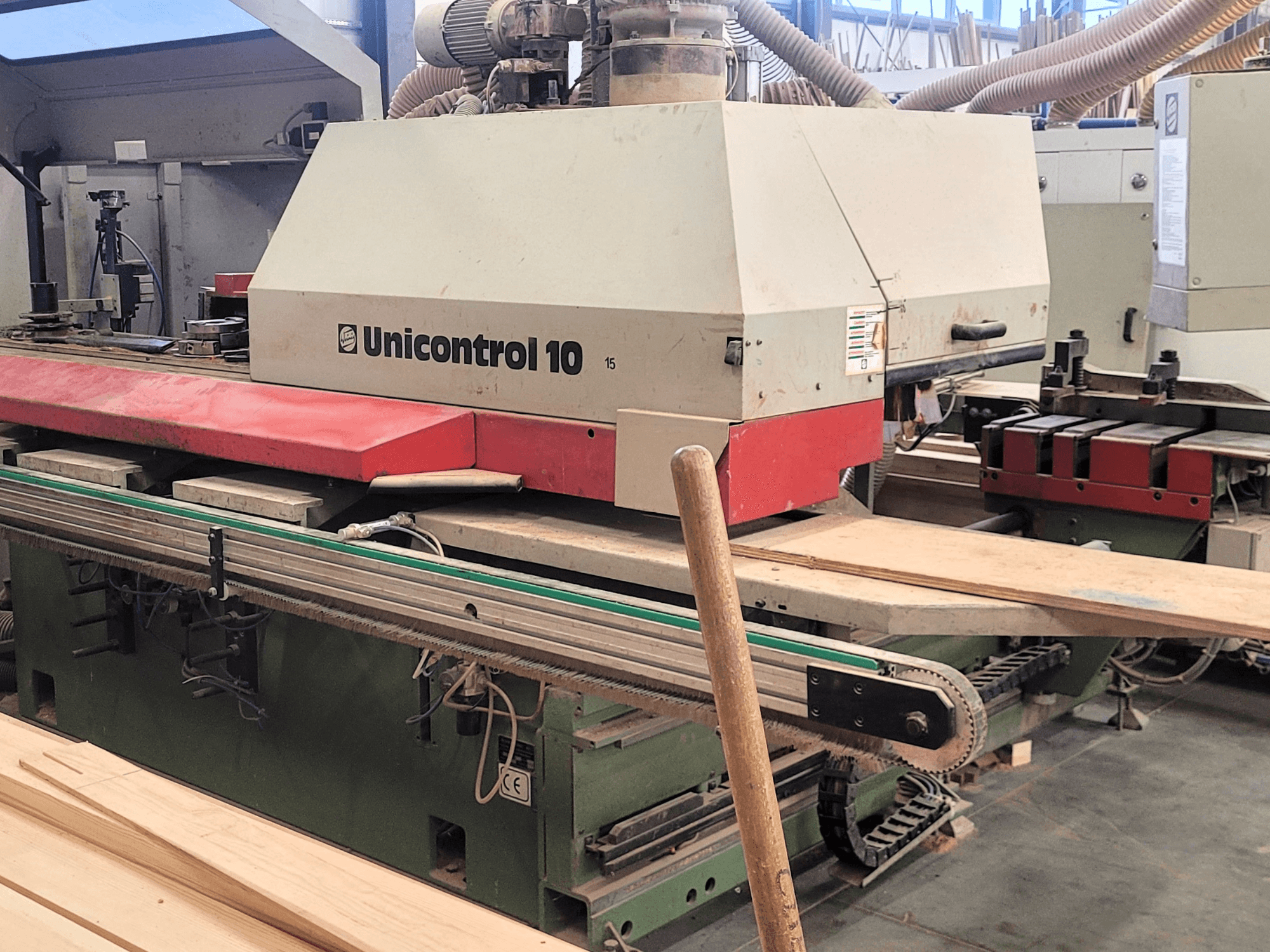 CNC-bewerkingscentrum Unicontrol 10 van WEINIG/DIMTER, vooraanzicht met houten planken en apparatuur in een werkplaats.