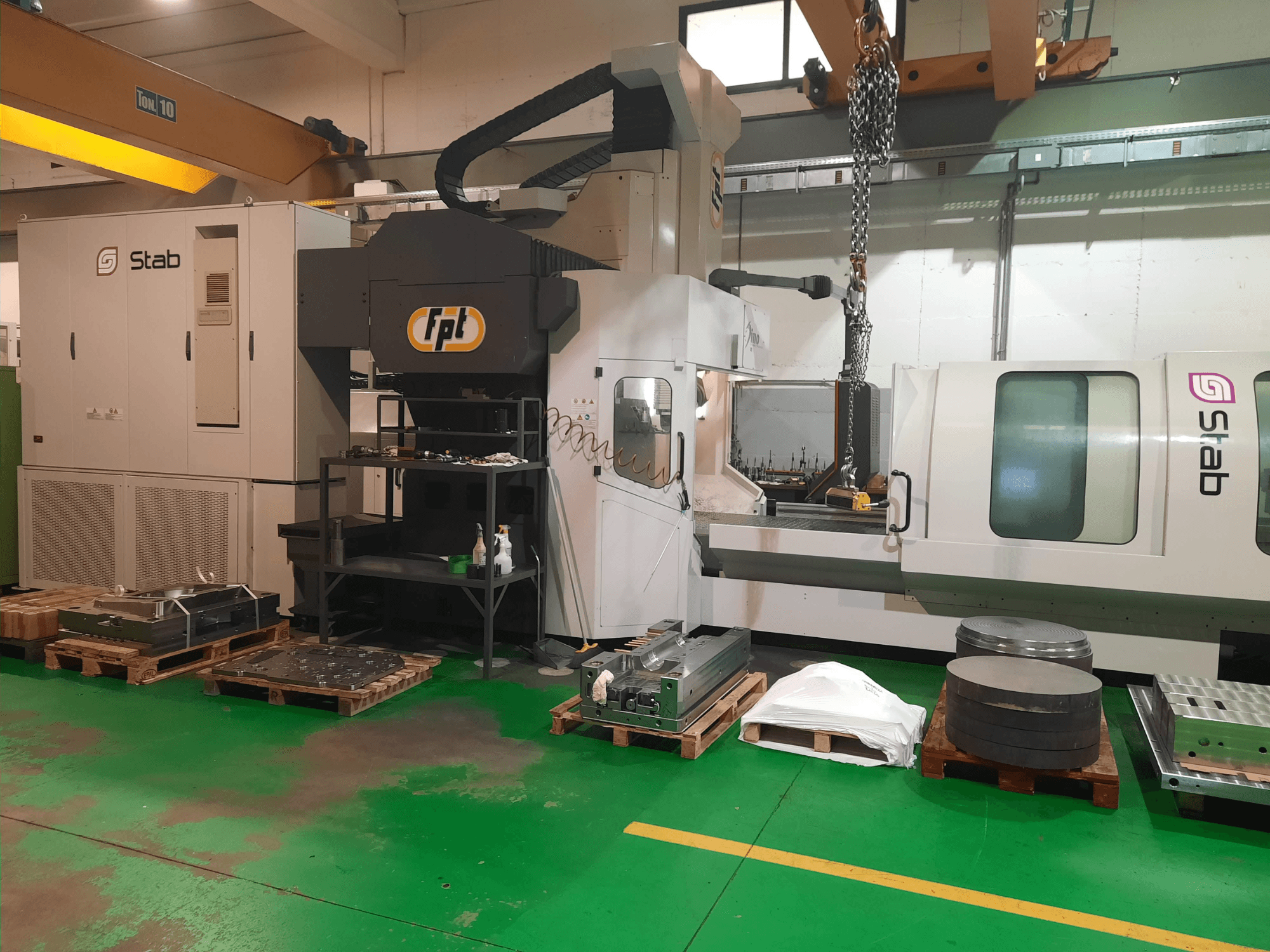 FPT DINO bedfreesmachine in een werkplaats, vooraanzicht met gereedschap en materiaal op pallets in de buurt.