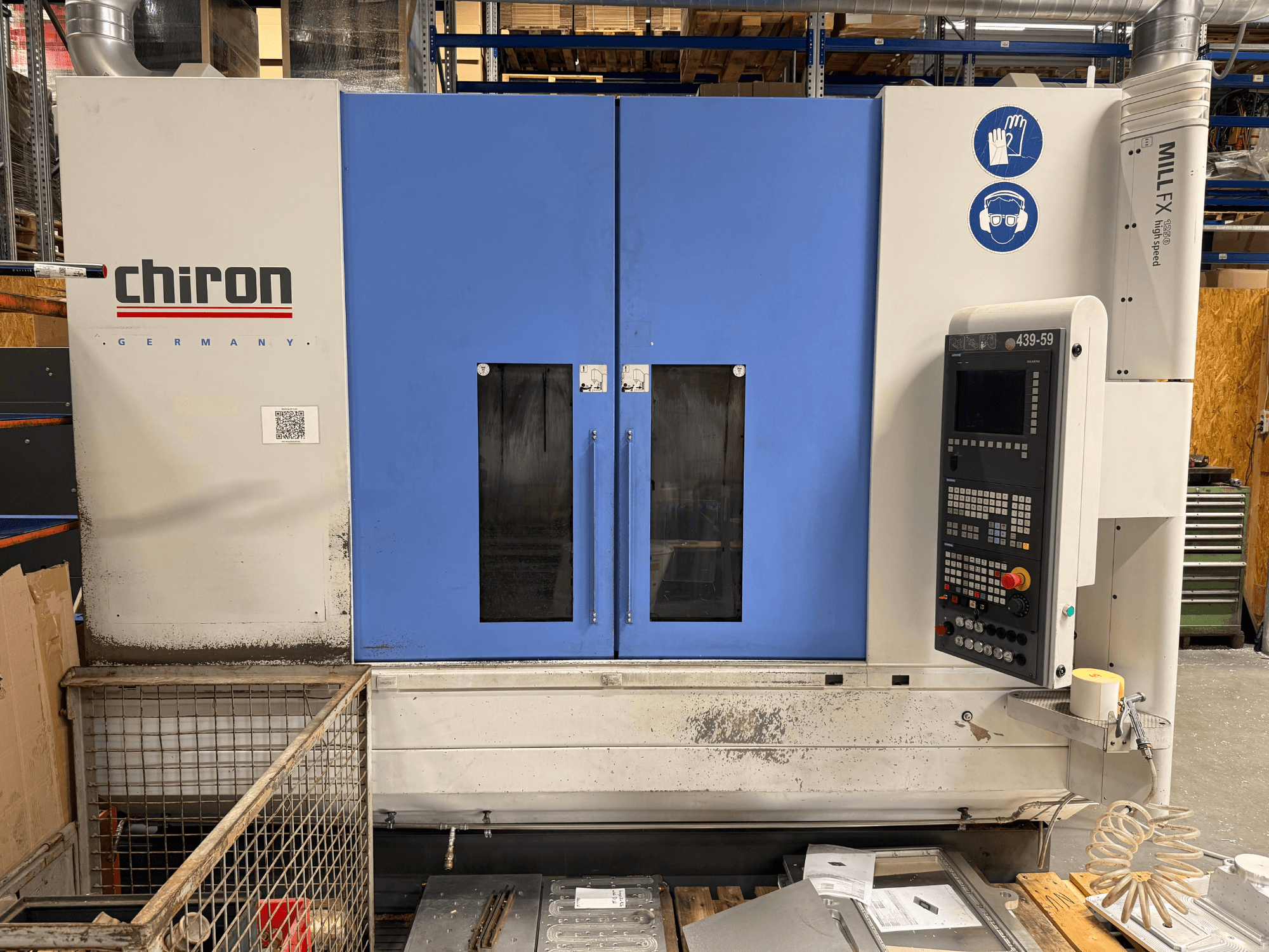 CHIRON MILL FX 1250 verticaal bewerkingscentrum, vooraanzicht, met bedieningspaneel en veiligheidssymbolen, klaar voor precisiewerk.