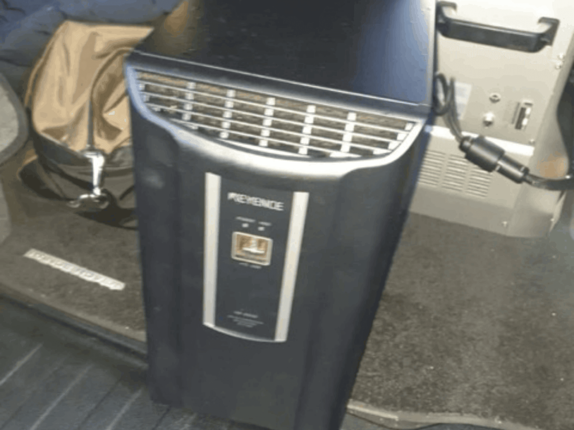 KEYENCE IM-8030 automatiseringssysteem in vooraanzicht, met het bedieningspaneel en de ventilatieopeningen tegen de achtergrond van het interieur van het voertuig.