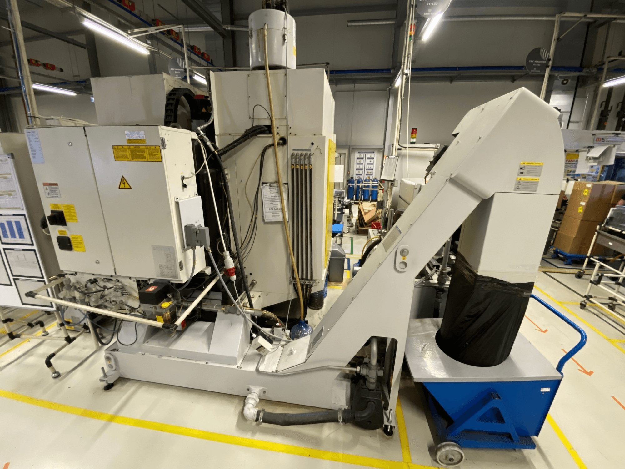 FANUC ROBODRILL α-D21LiB verticaal bewerkingscentrum, vooraanzicht, met daarin de elektrische componenten en de afvoergoot.