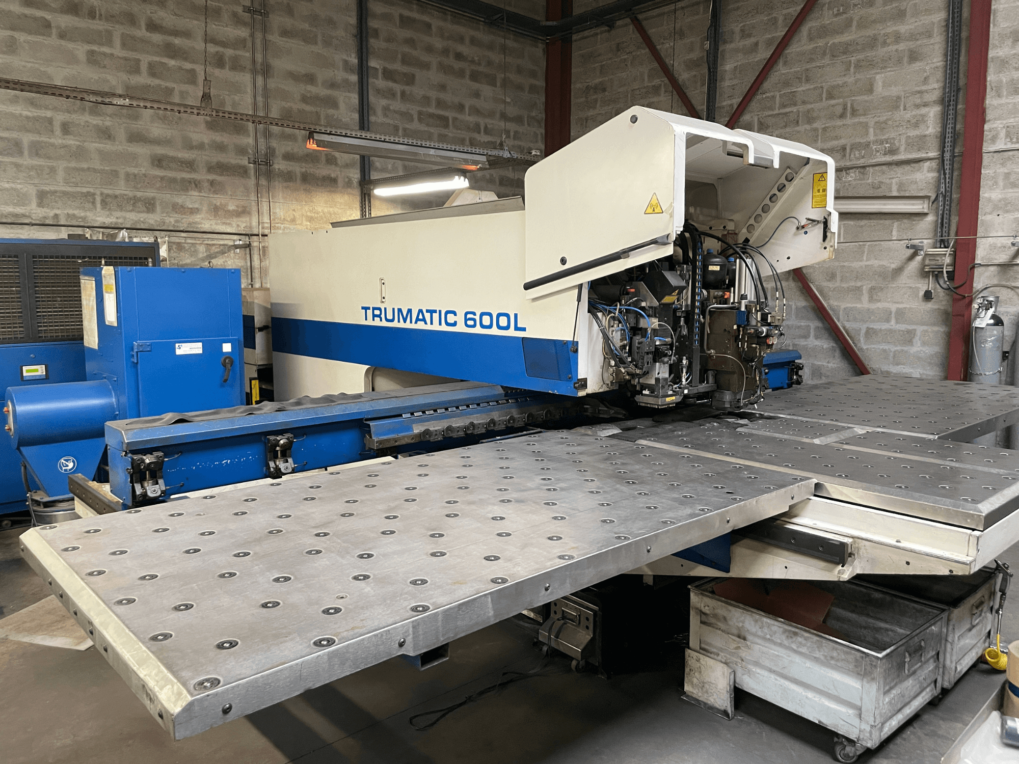 CO2 lasersnijmachine TRUMPF TRUMATIC TC 600L, vooraanzicht met metalen snijtafel en bedieningspaneel zichtbaar.