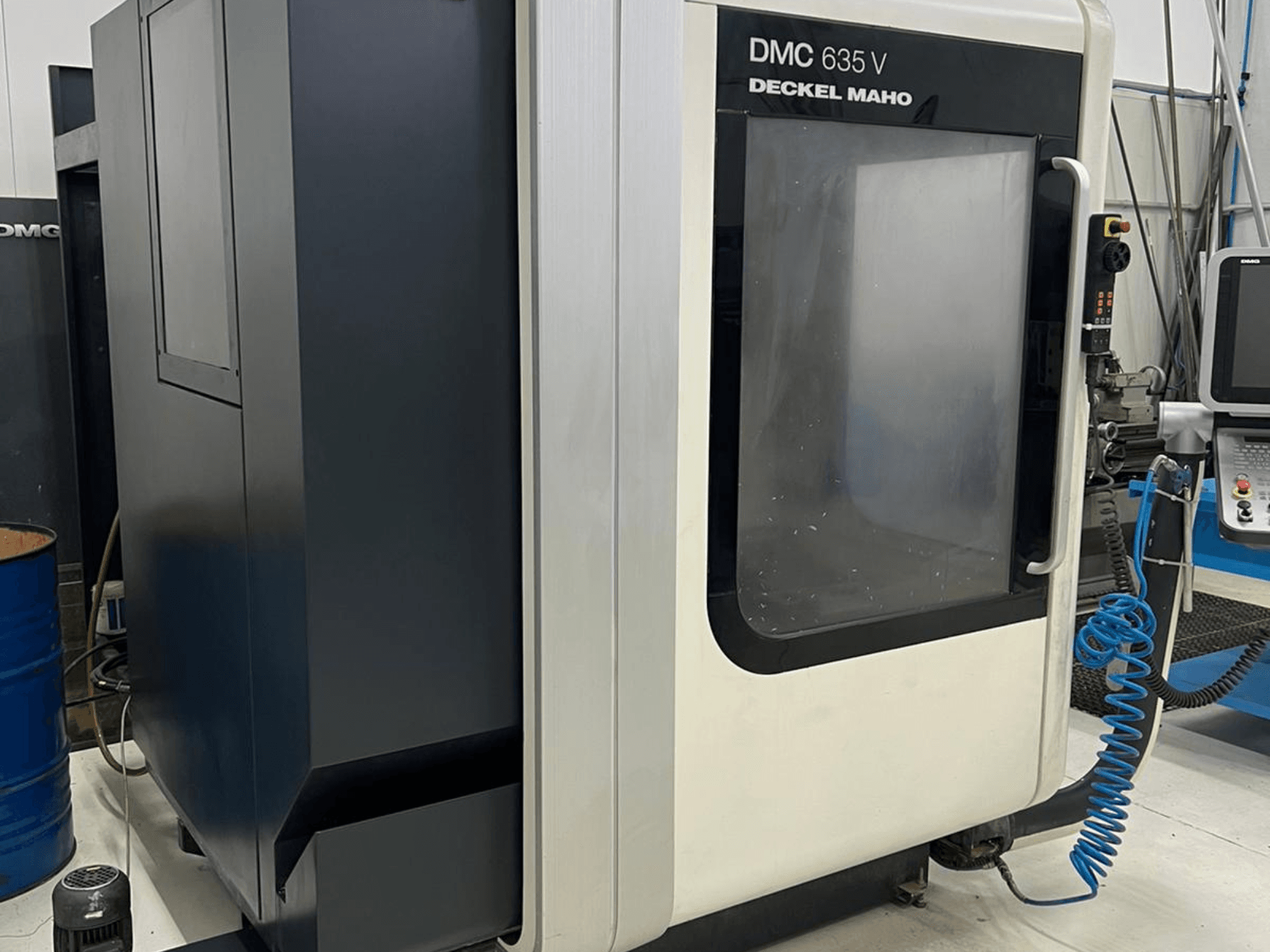DMC 635 V freesmachine van Deckel Maho, zijaanzicht met bedieningspaneel en gedeeltelijk geopende toegangsdeur.