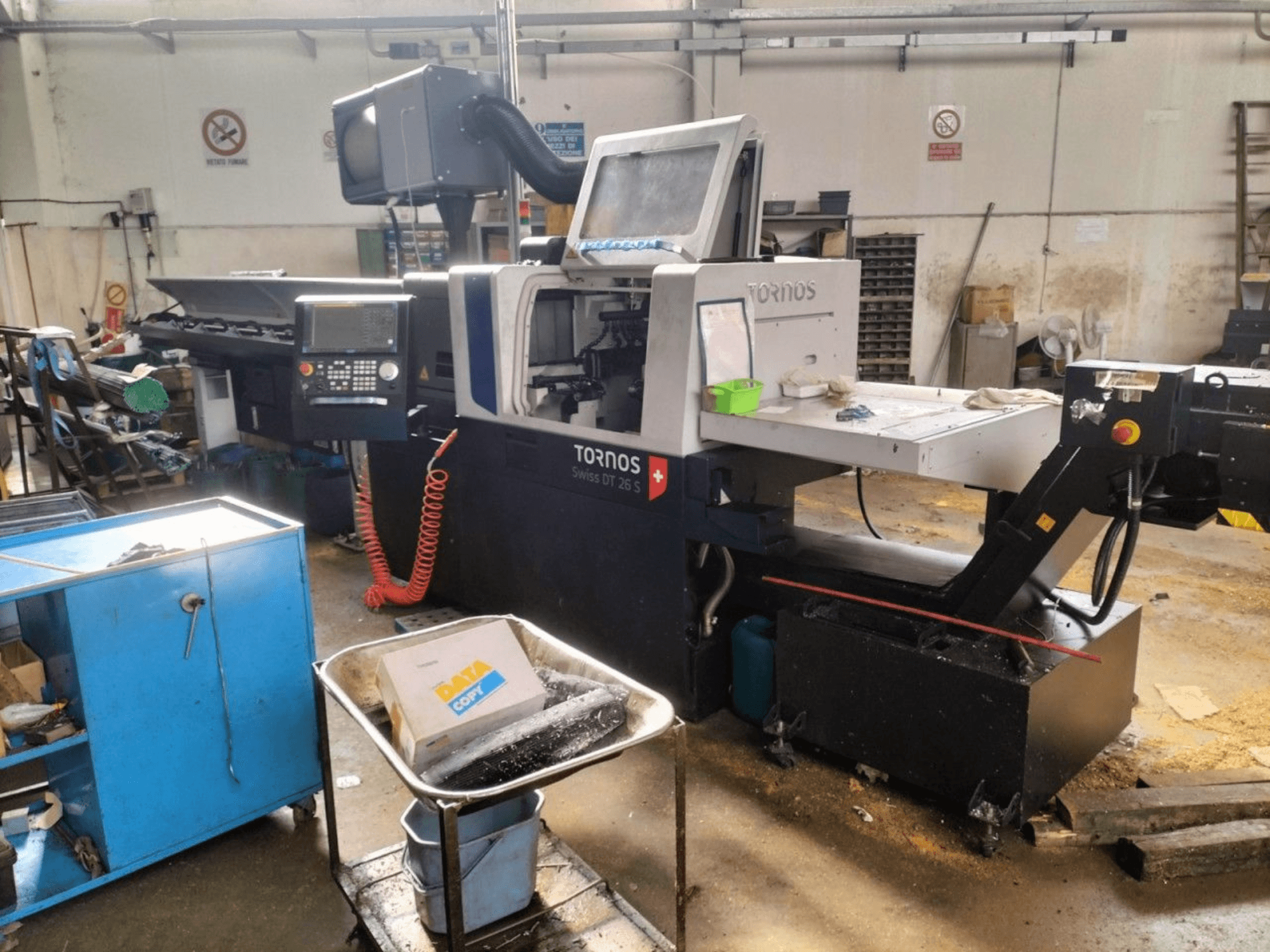 TORNOS Swiss DT 26 S Zwitserse draaimachine, vooraanzicht, met weergave van het bedieningspaneel, de werkruimte en de omringende industriële omgeving.