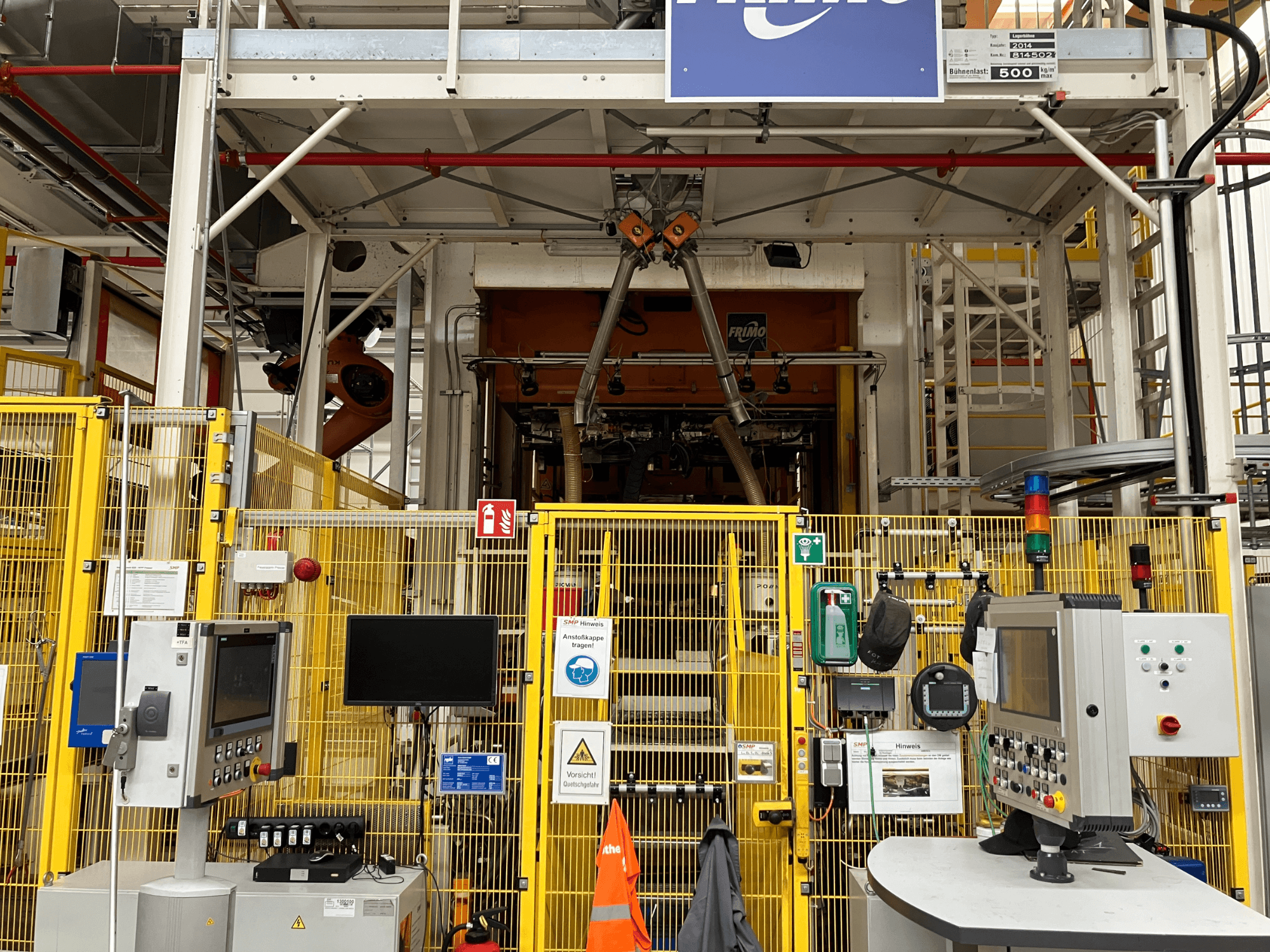 FRIMO NFPP-dieptrekmachine vooraanzicht, met bedieningspanelen en veiligheidshekken in een goed verlichte industriële omgeving.