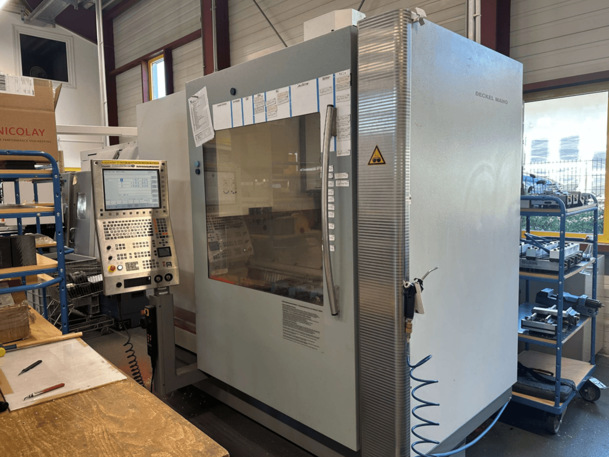 DMG DECKEL MAHO 1035V verticaal bewerkingscentrum, zijaanzicht met bedieningspaneel en machinestructuur, in een werkplaats.