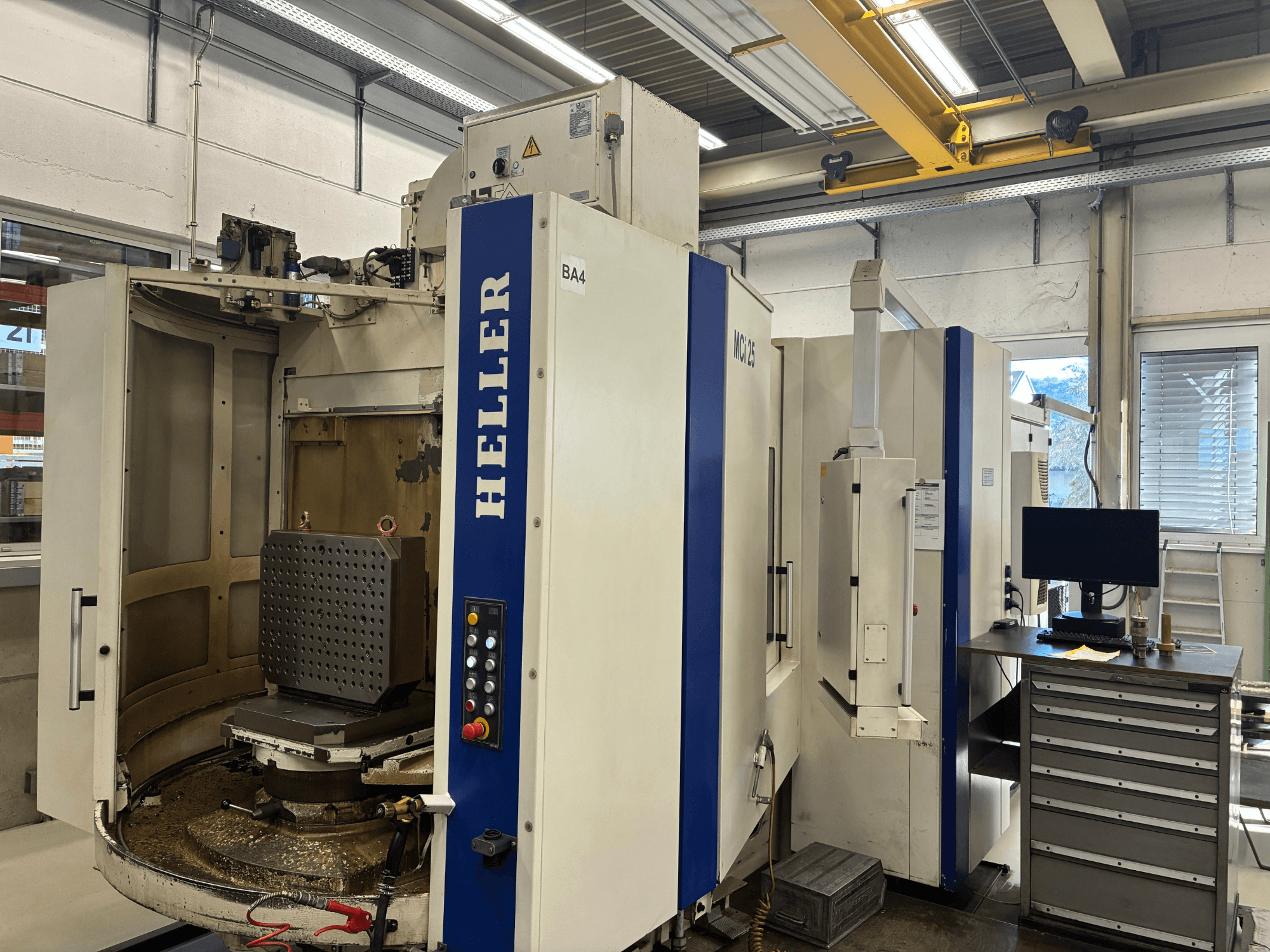 Horizontaal bewerkingscentrum HELLER MCi 25, vooraanzicht; heeft een werktafel waarop een zeshoekige opspanning en bedieningspaneel zichtbaar zijn.