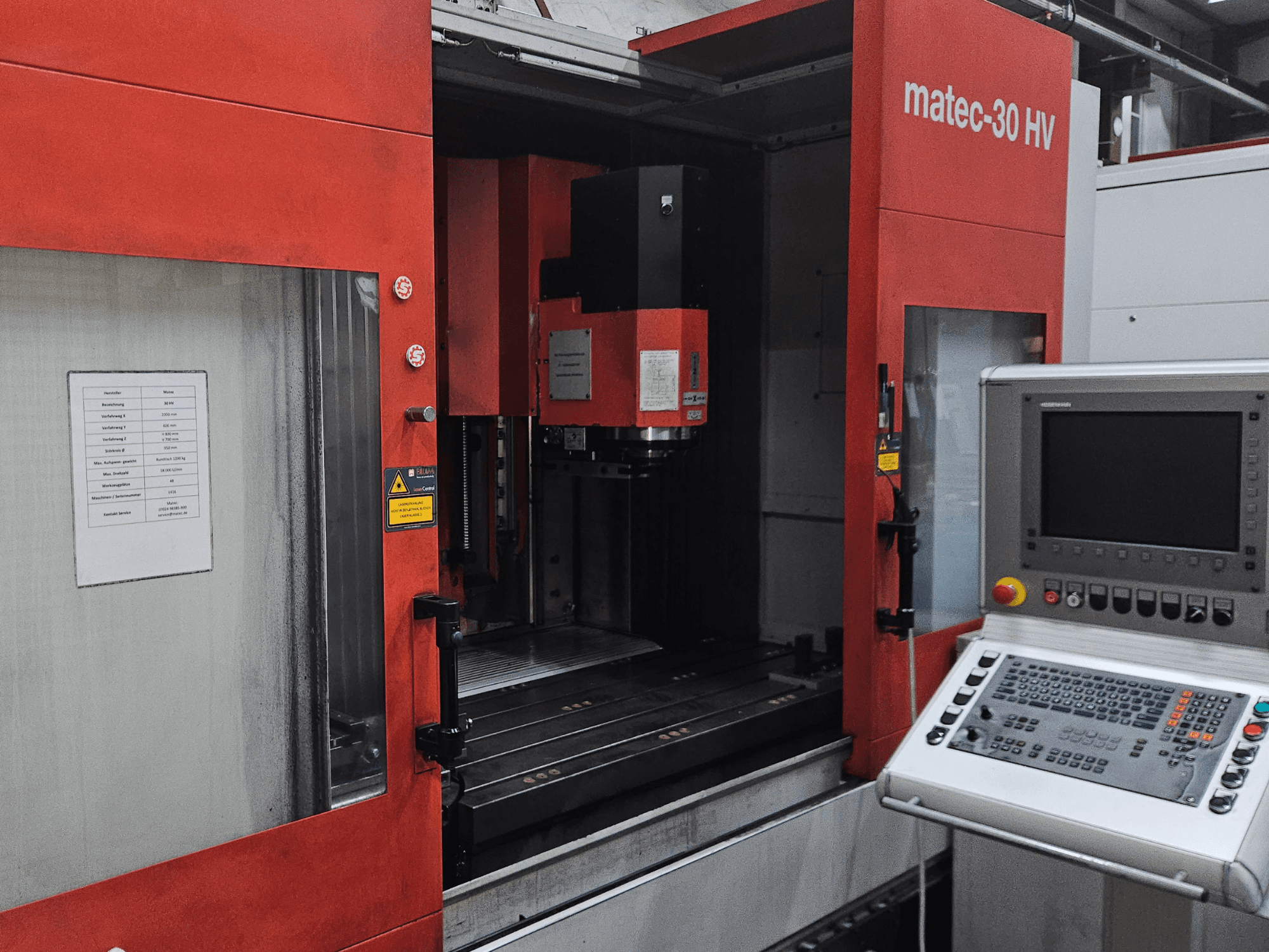 Vooraanzicht van een Matec 30 HV verticaal bewerkingscentrum, met het bedieningspaneel en operationele details op de machine.
