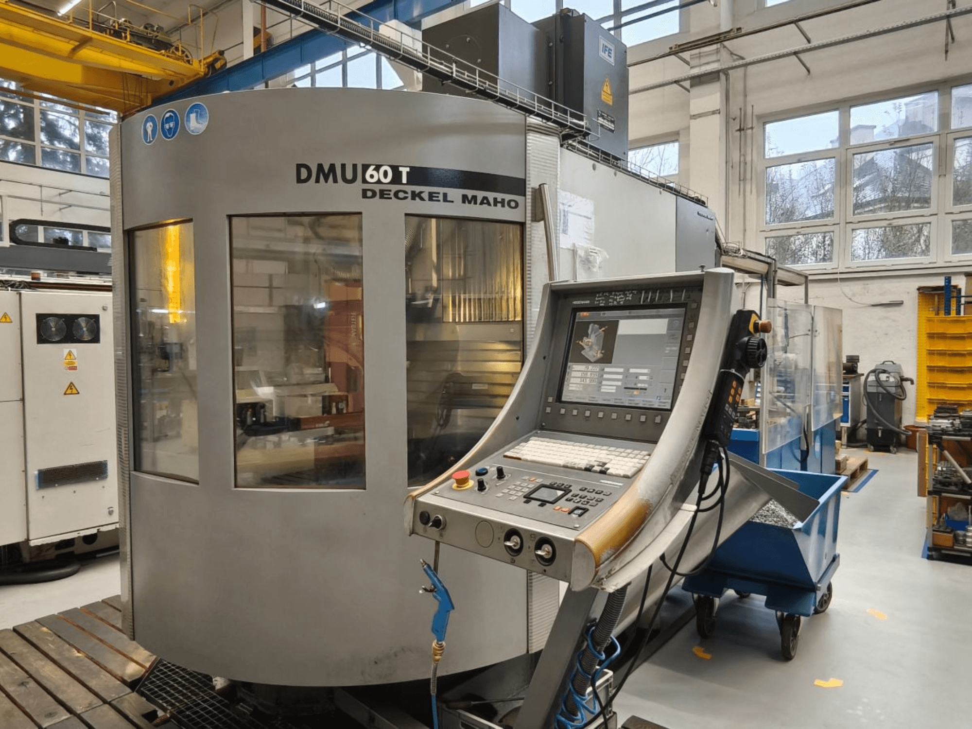 Verticaal zicht van DECKEL MAHO DMU 60T bewerkingscentrum met bedieningspaneel, waarop precisiegereedschappen worden weergegeven in een werkplaats.