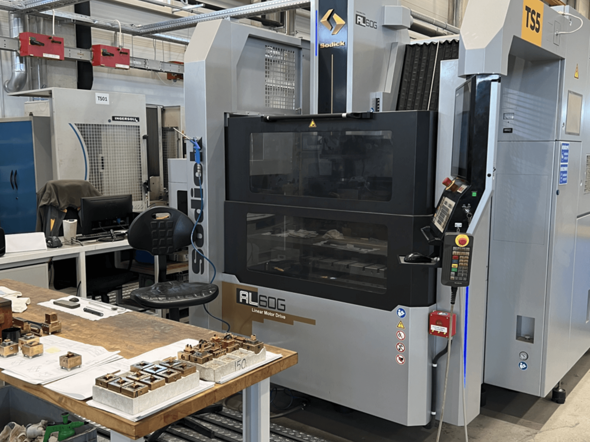 Sodick AL60G zinkvonkmachine; vooraanzicht met bedieningselementen, venster en werkruimte met diverse metalen onderdelen.