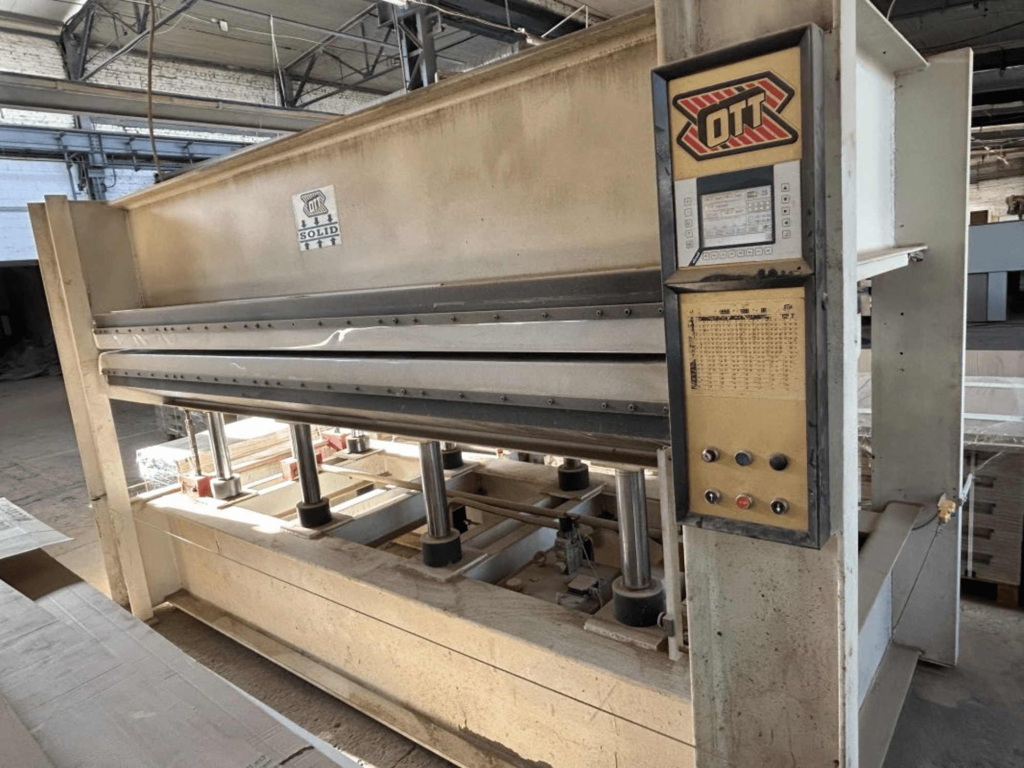 Vooraanzicht van de OTT SOLID 16-32 lamineermachine, met het bedieningspaneel en de hydraulische onderdelen.
