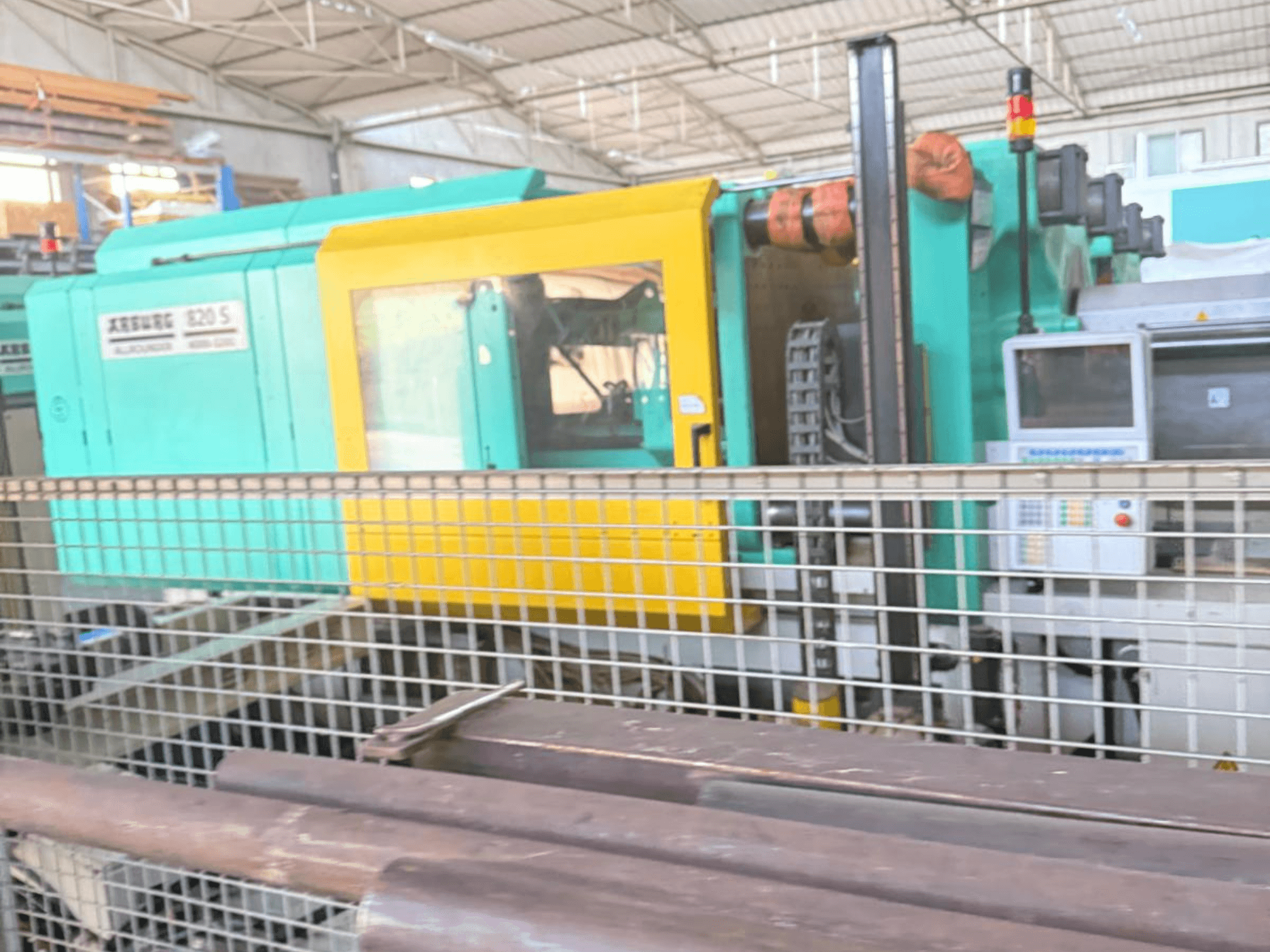 Hydraulische spuitgietmachine Arburg SELECTA 820 S 4000-3200, zijaanzicht, bedieningspaneel en levendig geel en groenblauw ontwerp.