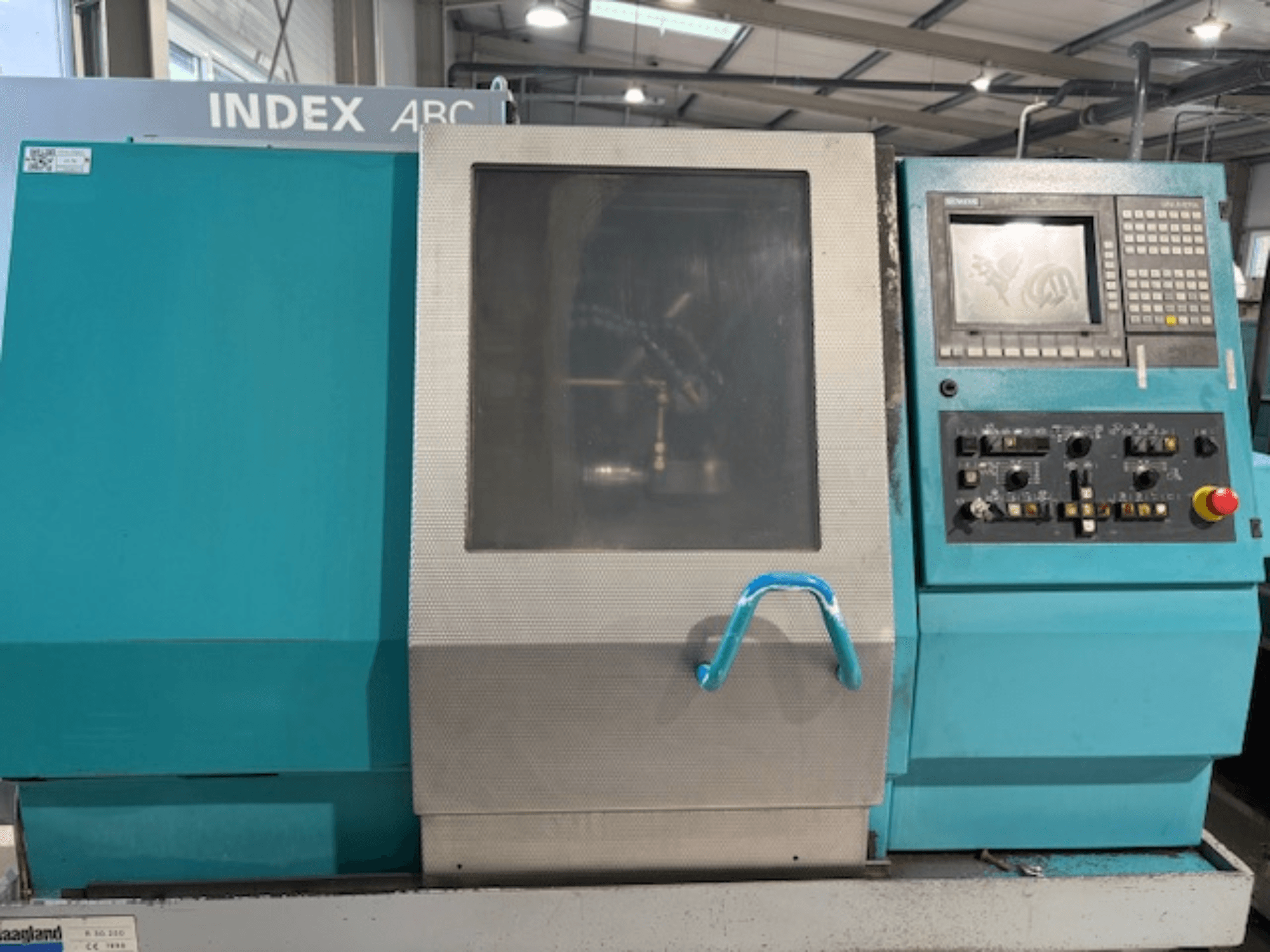 Index ABC 63 Horizontale draaimachine, vooraanzicht met bedieningspaneel, blauwe behuizing en transparant venster.