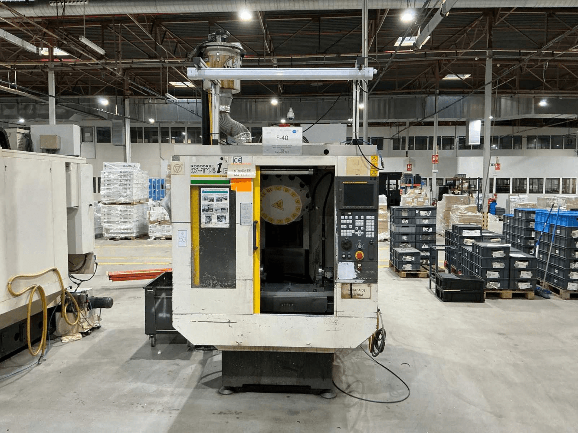 FANUC ROBODRILL α-T14iB verticaal bewerkingscentrum in een fabriek, vooraanzicht met bedieningspaneel en gereedschapshouder.