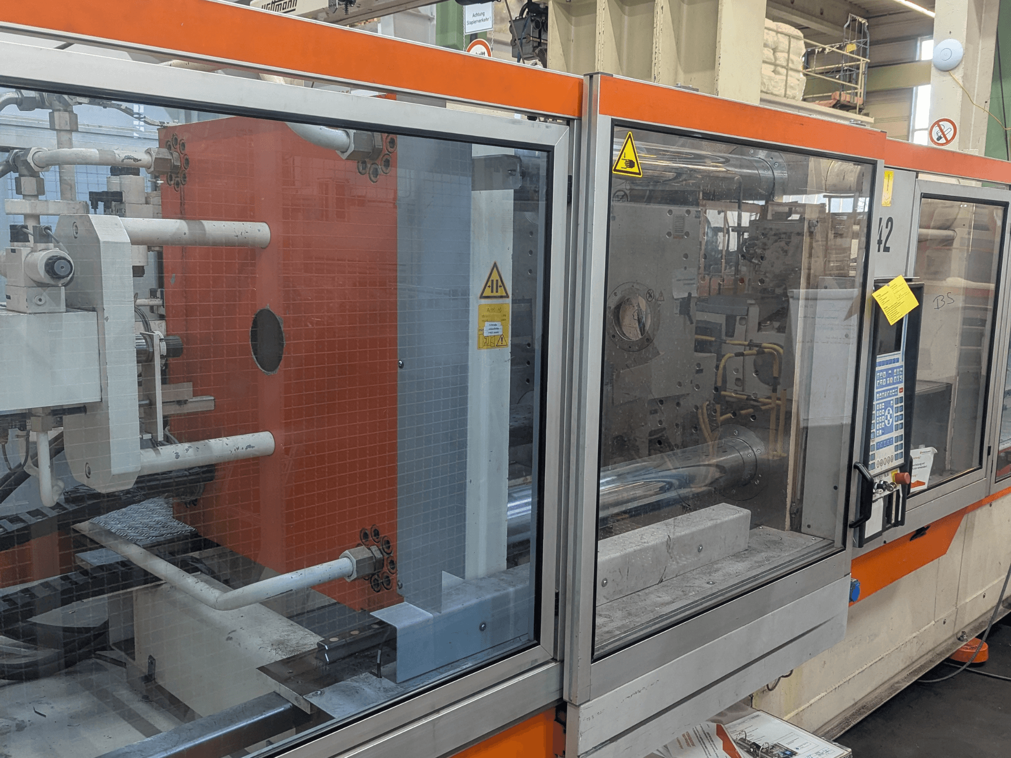 Vooraanzicht van een DEMAG SYSTEC 80/420-310 hydraulische spuitgietmachine met zichtbaar bedieningspaneel en machineonderdelen.