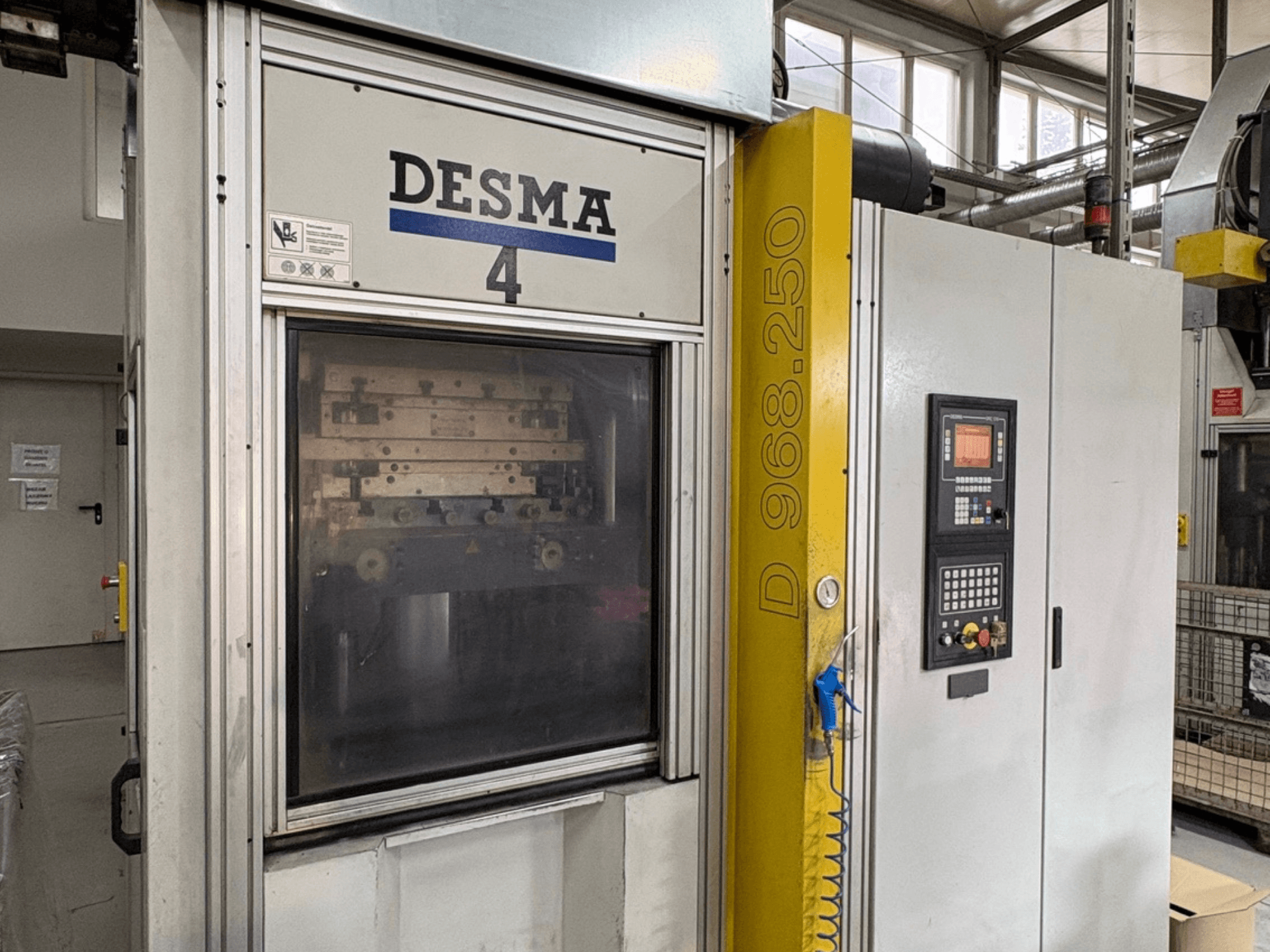 Verticale spuitgietmachine Kloeckner Desma 968.250, vooraanzicht met bedieningspaneel en machinedetails.