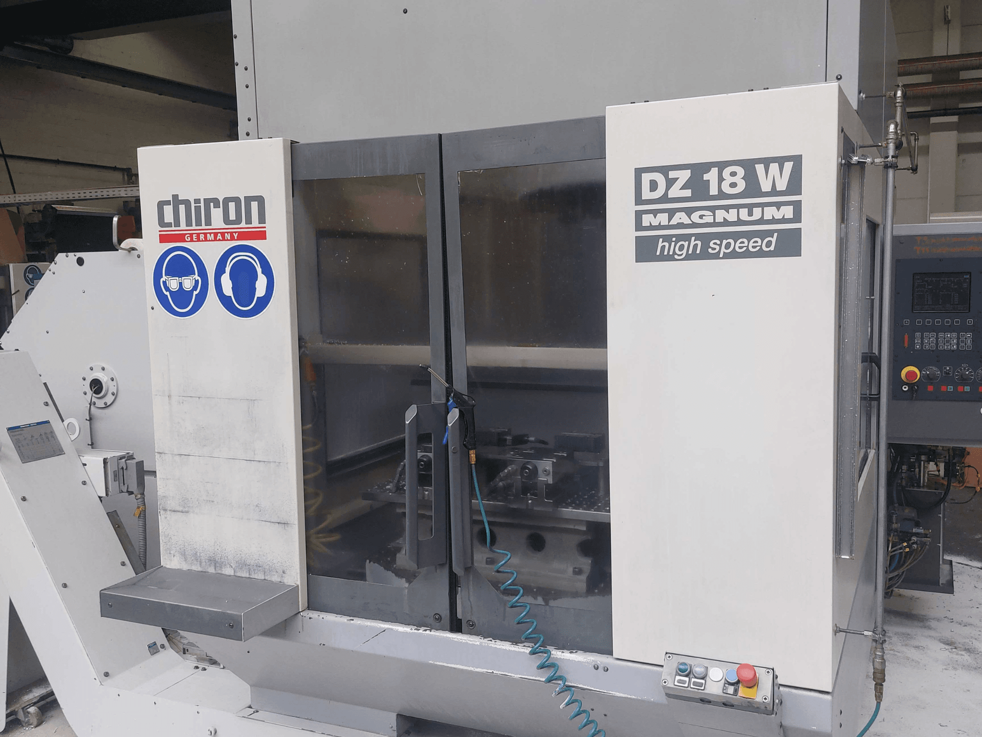CHIRON DZ 18 W MAGNUM verticaal bewerkingscentrum, vooraanzicht met bedieningspaneel en veiligheidsmarkeringen.