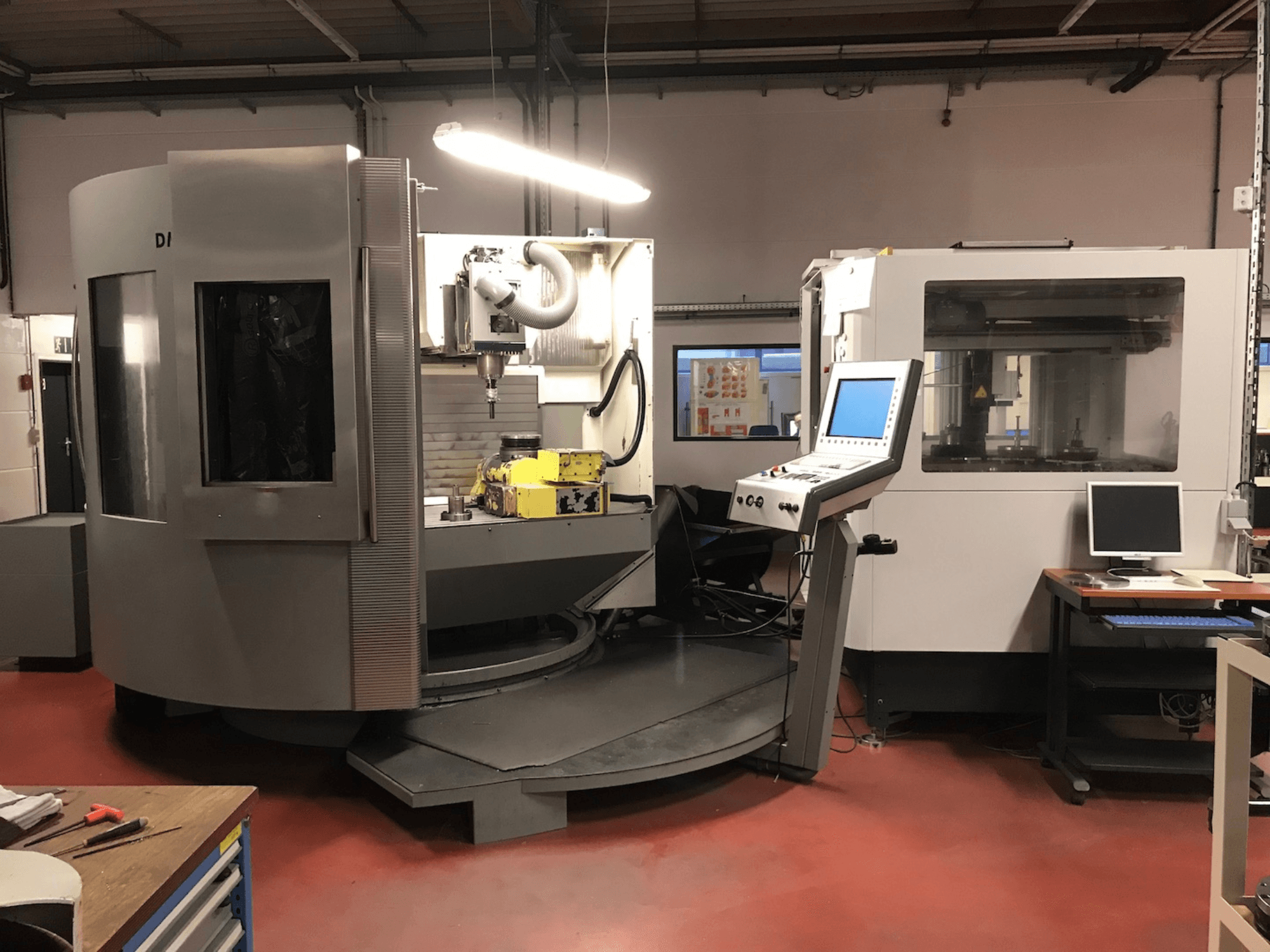 Universeel bewerkingscentrum DMU 100T van DMG DECKEL MAHO, zijaanzicht met bedieningspaneel en draaibare basis.