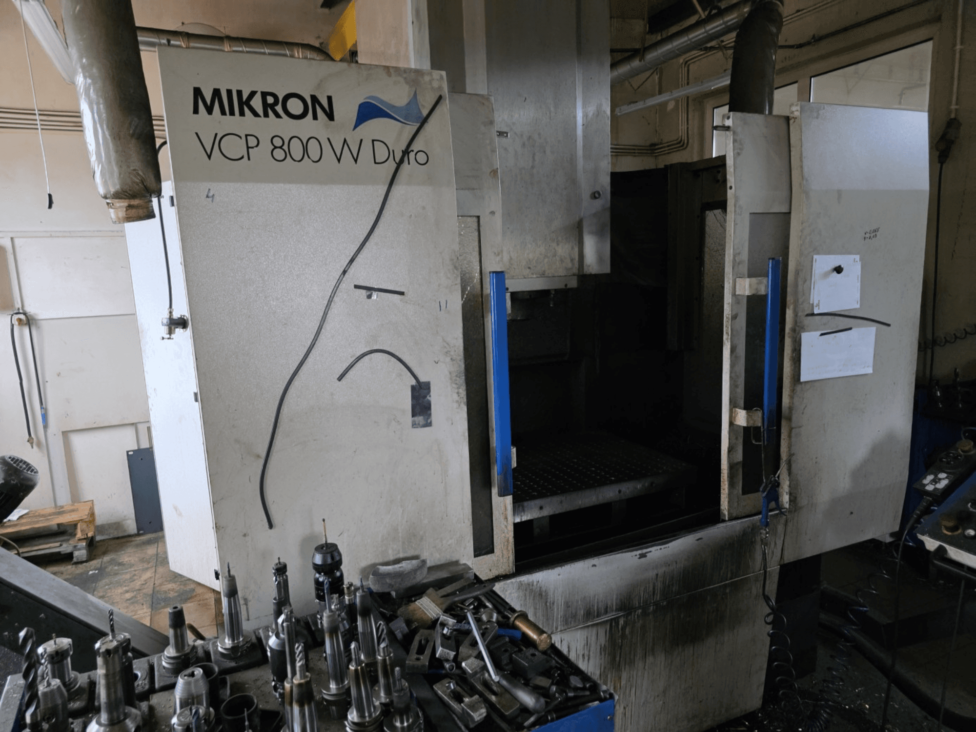 Mikron VCP 800 W Duro freesmachine in zijaanzicht, met gereedschappen en bedieningselementen zichtbaar op de voorgrond.