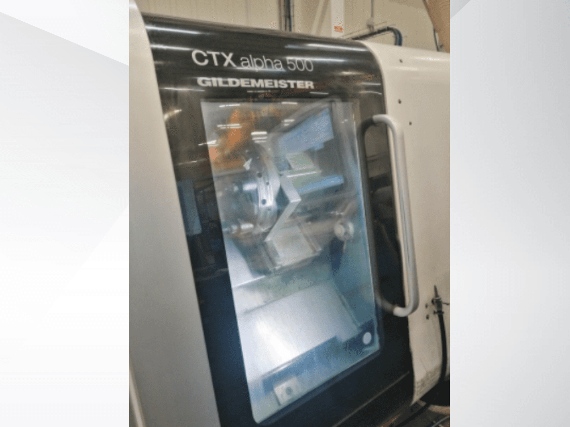 CTX alpha 500 Gildemeister CNC machine, vooraanzicht, met de spindel en het bewerkingsgebied door de glazen deur.