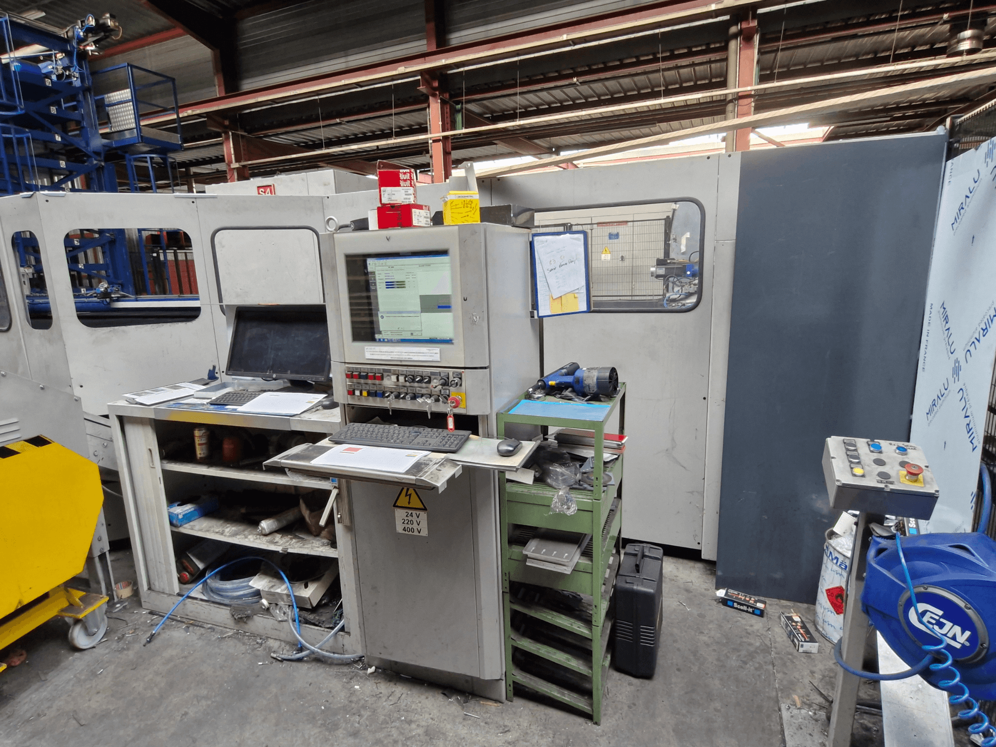 CNC ponsmachine Salvagnini S4-40 in een werkplaats, met een bedieningspaneel met monitors en gereedschappen, vooraanzicht.