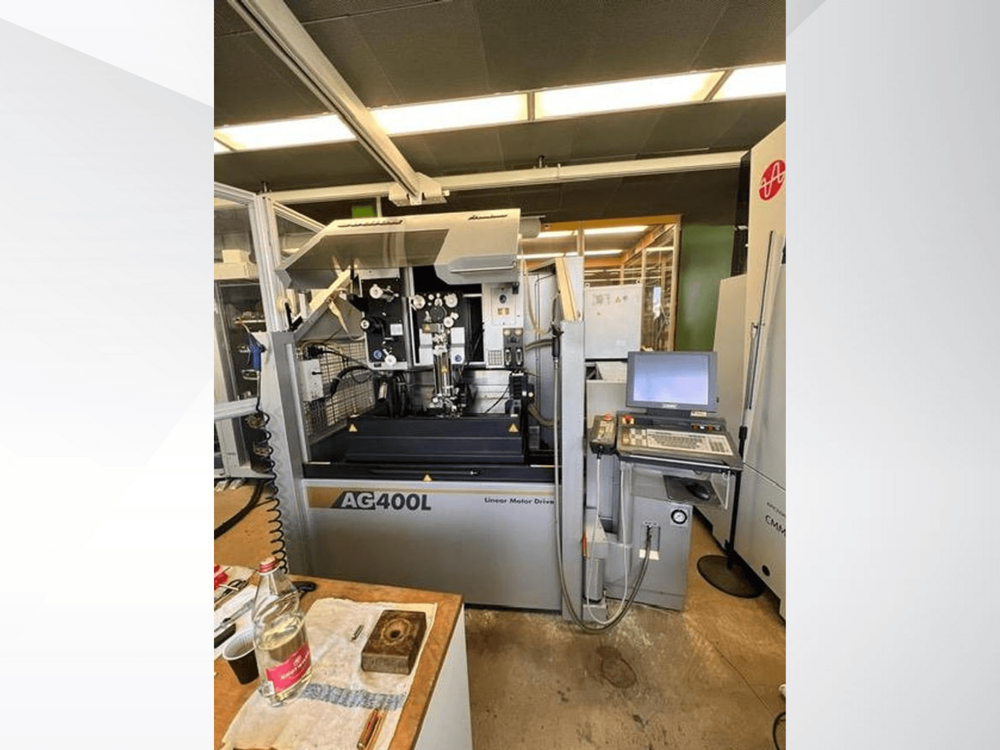 Machine met lineaire aandrijving AG400L, vooraanzicht, met bedieningspaneel en werkgebied met zichtbare veiligheidsfuncties.