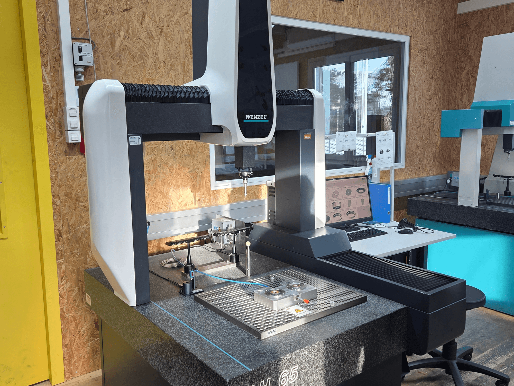 Wenzel LH 65 coördinatenmeetmachine in een labopstelling, vooraanzicht, met meetinstrumenten en een monitor.