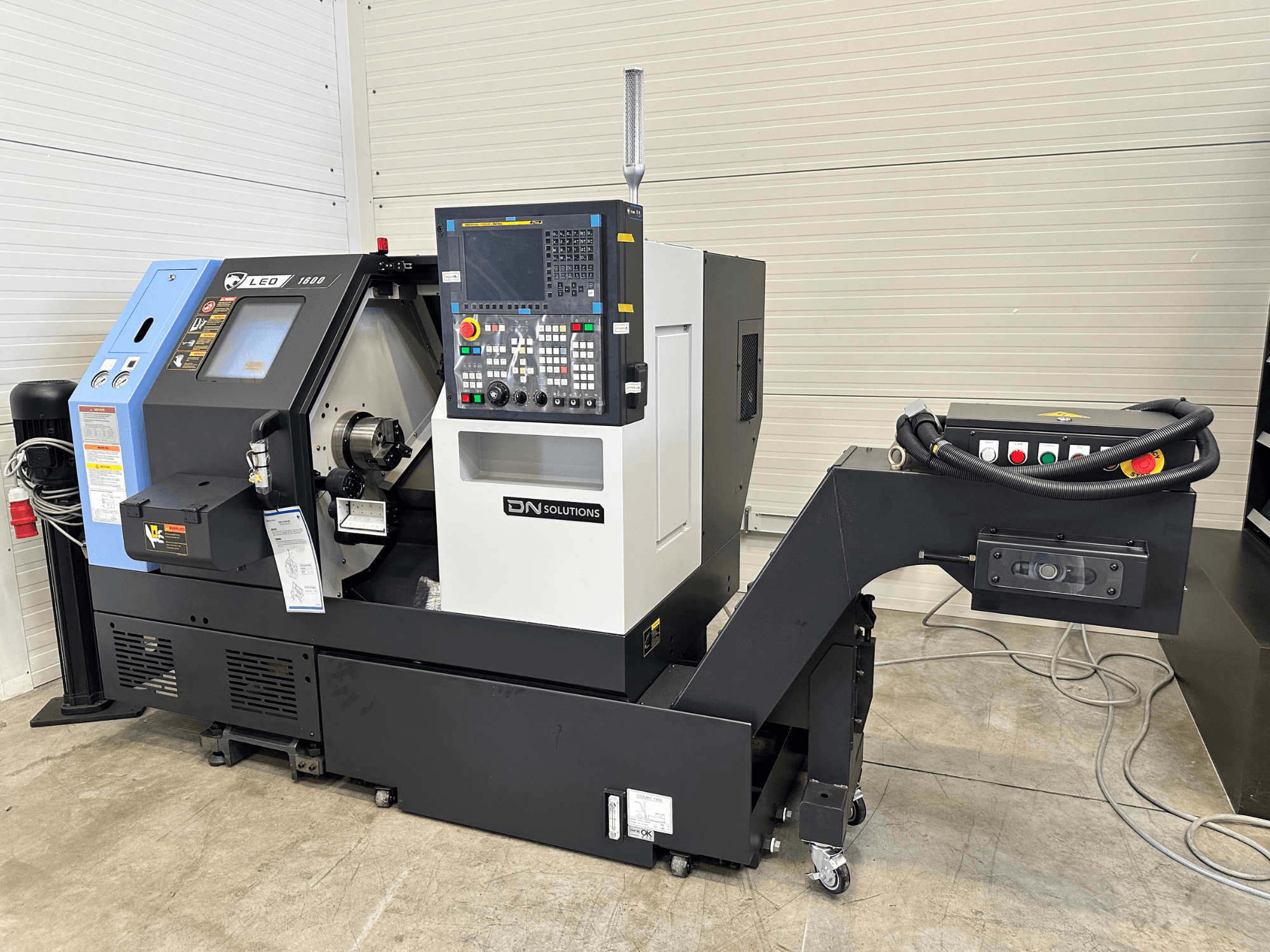 Vooraanzicht van DN SOLUTIONS Leo 1600 draai-freescentrum, met een digitaal bedieningspaneel en gereedschapshouder, op een zwarte basis.