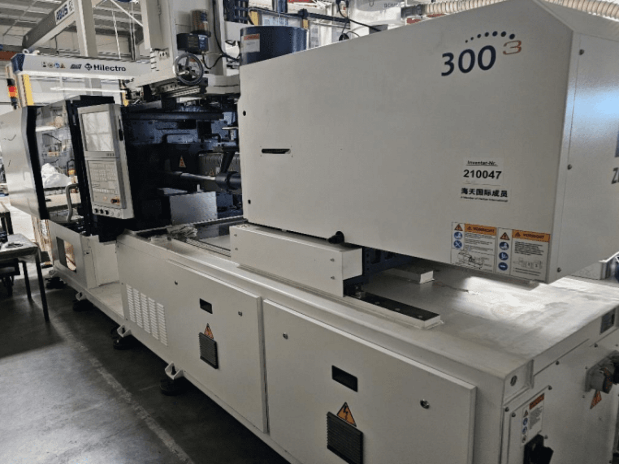 Spuitgietmachine, merk Zhenjing, model 300, vooraanzicht met bedieningspaneel en veiligheidswaarschuwingslabels zichtbaar.