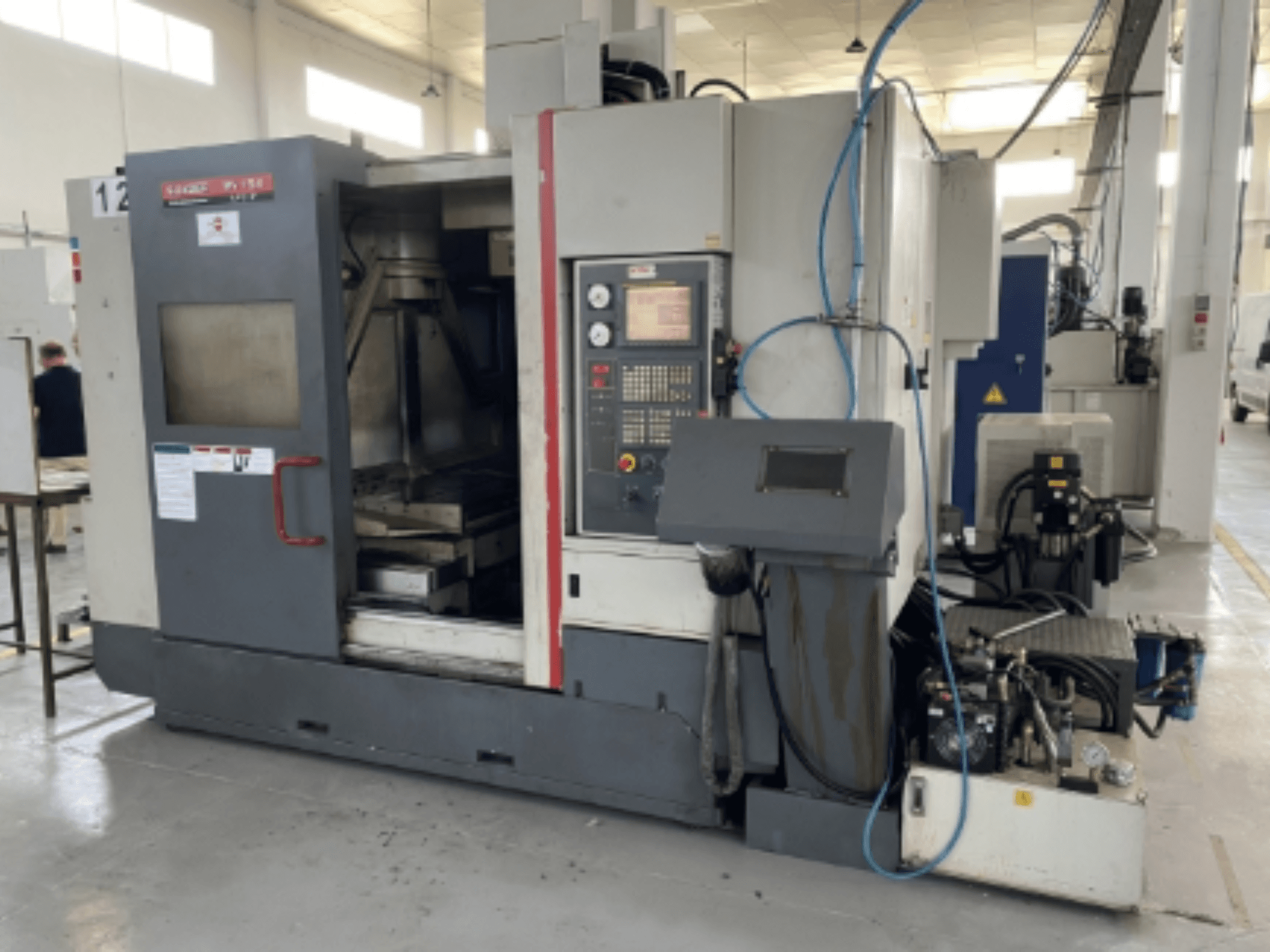 Quaser MV154APC-912 verticaal bewerkingscentrum, vooraanzicht met bedieningspaneel, geopende deur en machineonderdelen.