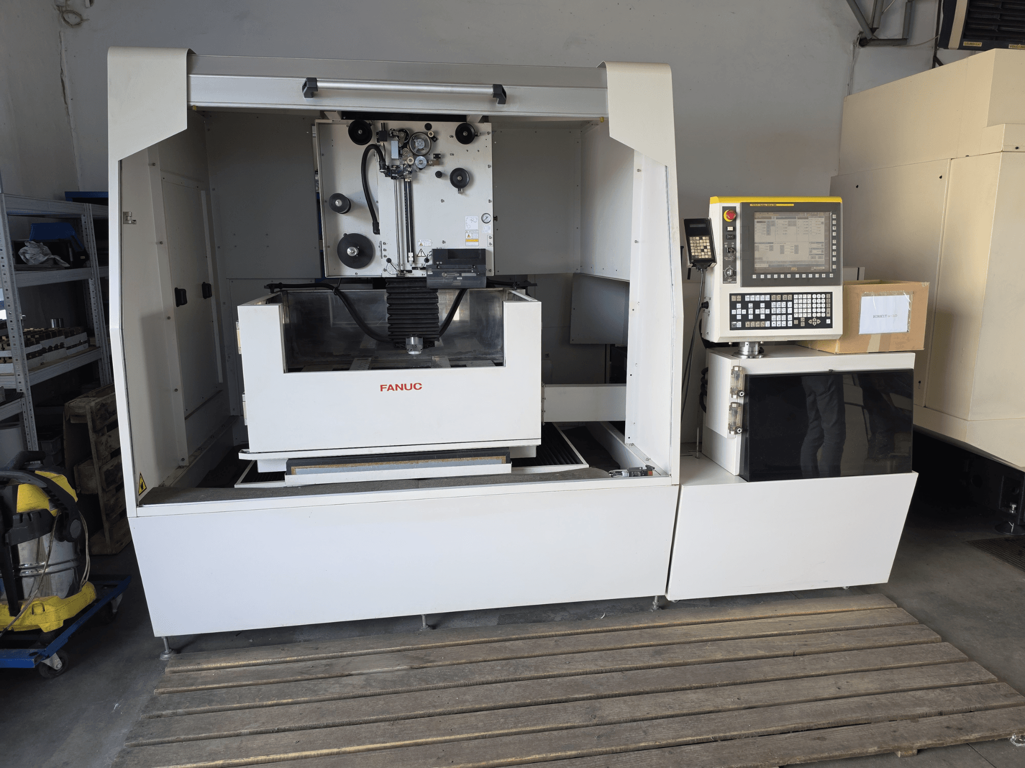 FANUC ROBOCUT alpha-1iD draad-EDM-machine, vooraanzicht met bedieningspaneel, werkgebied en compact ontwerp in een werkplaatsomgeving.