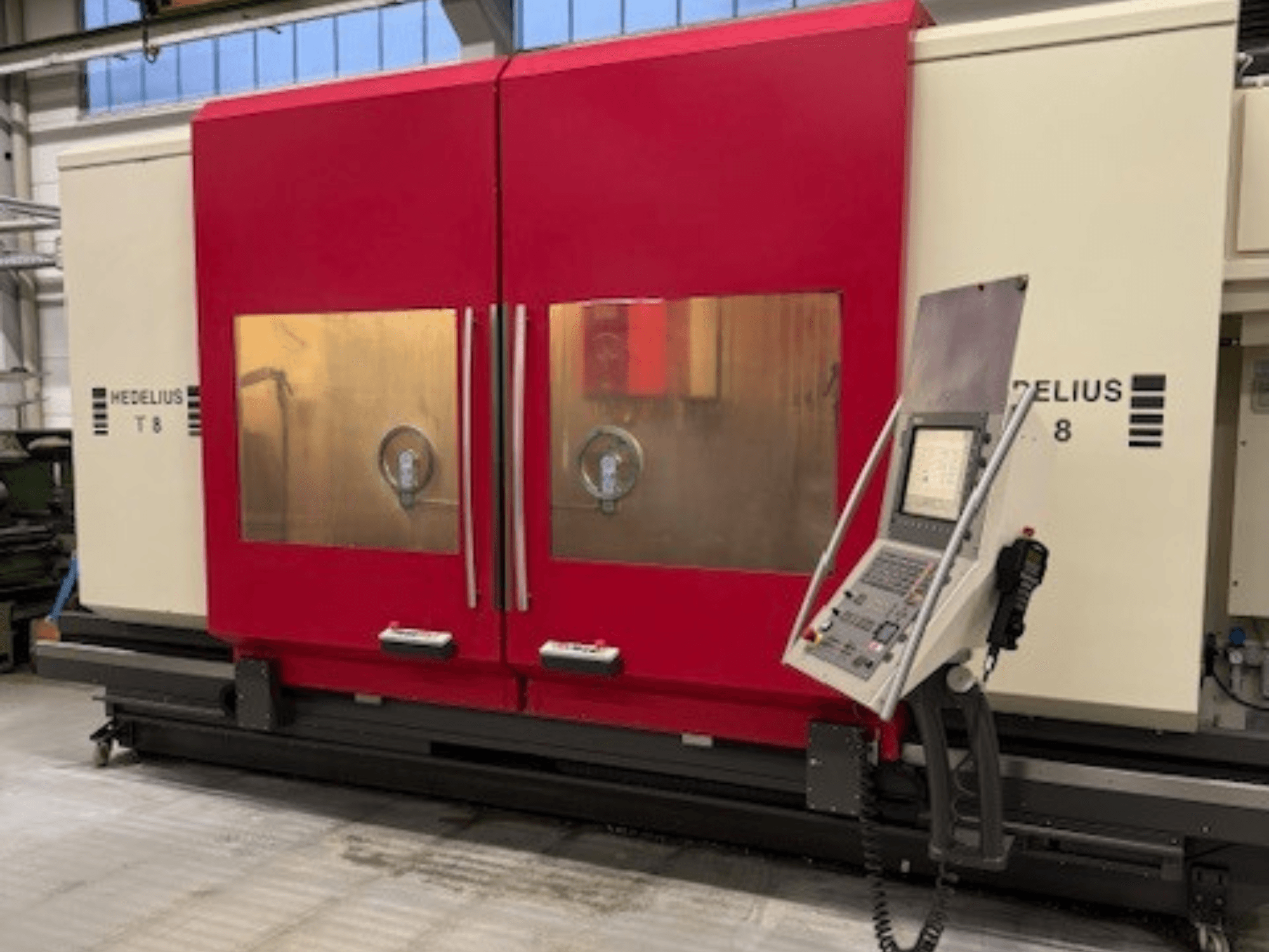 HEDELIUS T8 CNC machine in vooraanzicht, met rode deuren, bedieningspaneel en zicht op interne componenten.