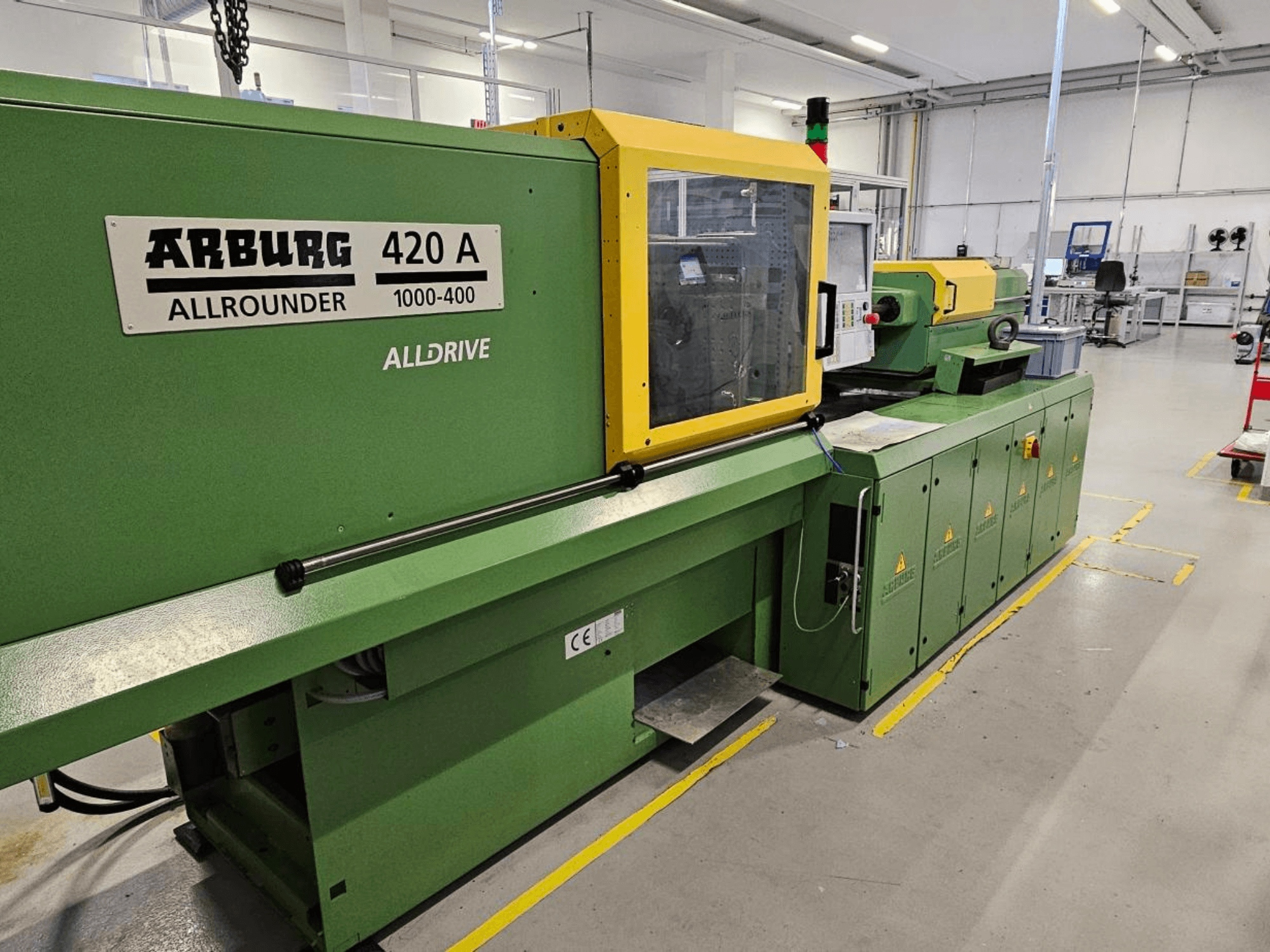 ARBURG 420 A Allrounder 1000-400, vooraanzicht; groene machine met geel paneel, touchscreen en veiligheidsvoorzieningen.