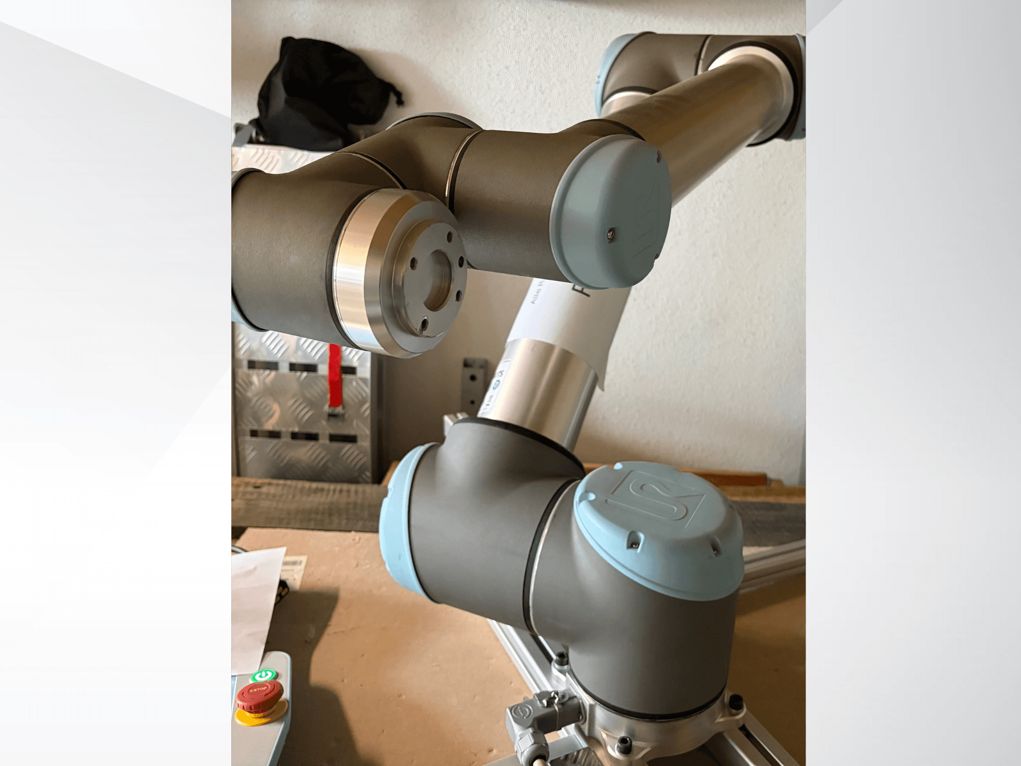 Close-up zijaanzicht van een Universal Robots UR10 robotarm, met de gewrichten en grijsblauwe ontwerpelementen.