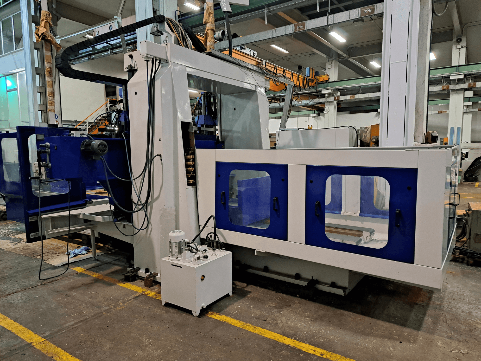 Een DYE RHE-3000 freesmachine van het bedtype in een werkplaats, vooraanzicht met het grote blauw-witte frame en het bedieningspaneel.