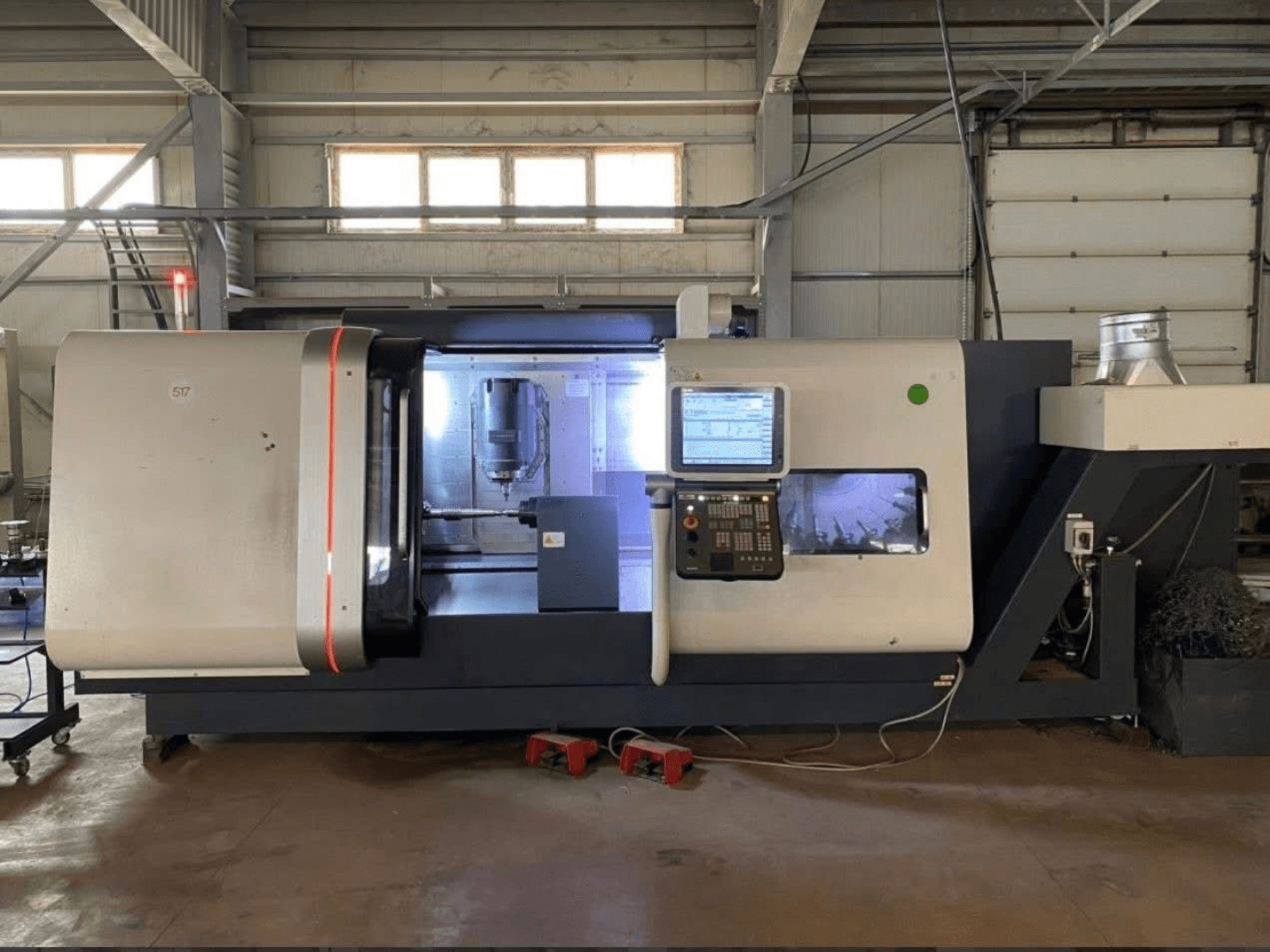 DMG MORI Beta 1250 TC draaifreescentrum, vooraanzicht met bedieningspaneel, verlichte werkruimte en zichtbaar snijgereedschap.