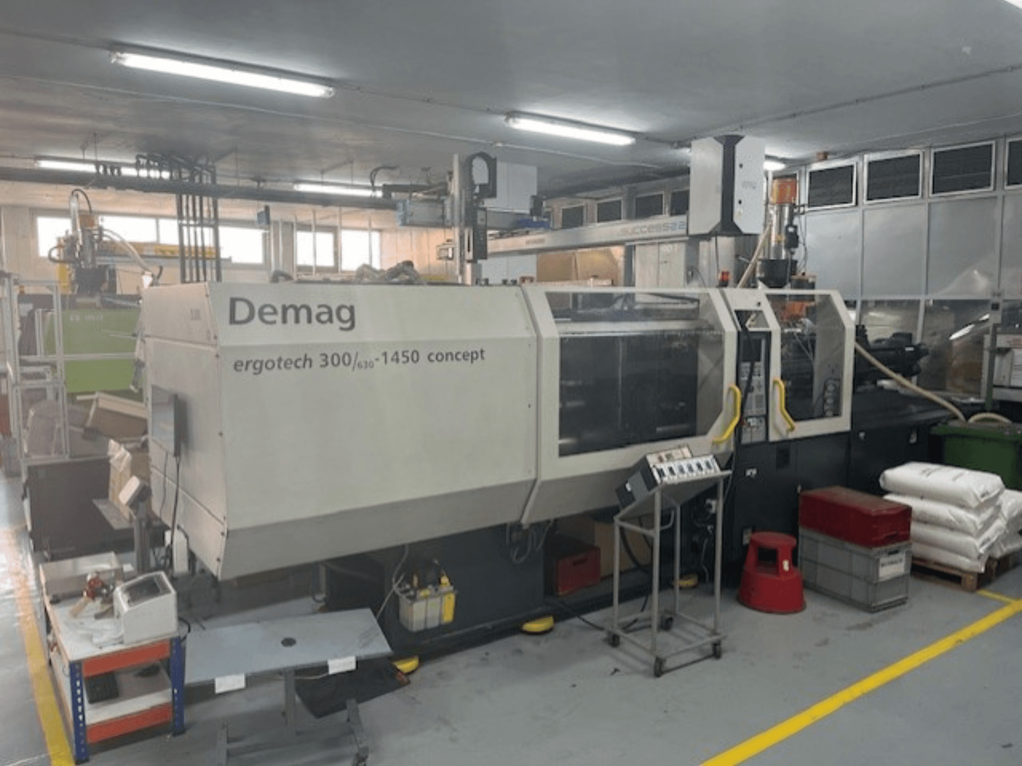 Demag ERGOTECH CONCEPT 3000-1450 hydraulische spuitgietmachine, vooraanzicht, met bedieningselementen en materialen in de buurt.