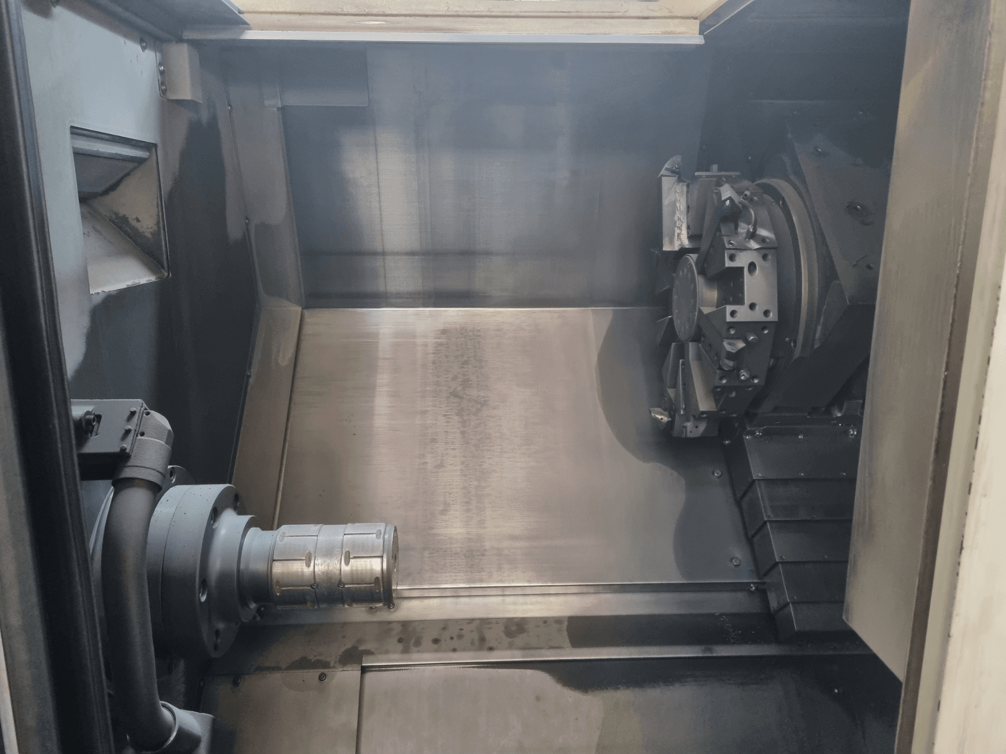Binnenaanzicht van een CNC machine met een metalen werkgebied, gereedschaphouder en klauwplaat; benadrukt precisie-engineering.