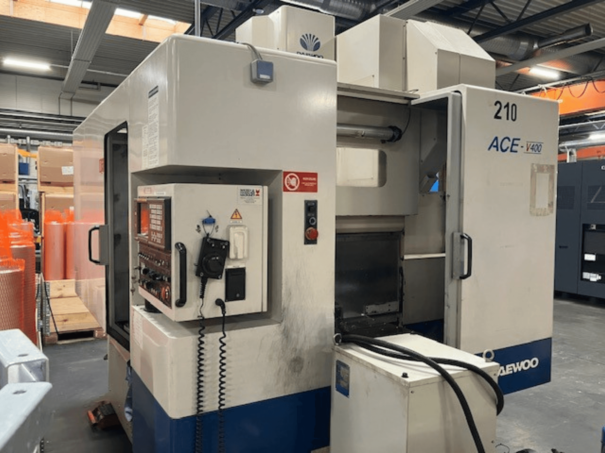 Daewoo ACE-V400 CNC machine in zijaanzicht, met bedieningspaneel, koelvloeistoftank en open werkgebied.